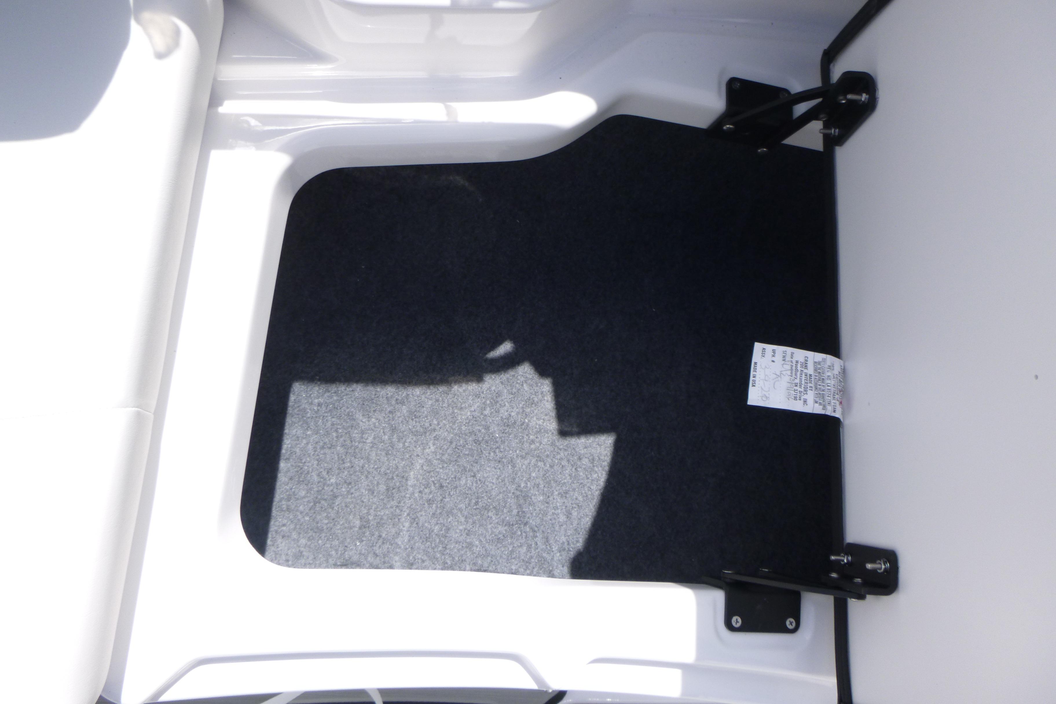 Storage compartment of 2026 Yamaha Boats 222S, featuring carpeted interior and hinge details.
