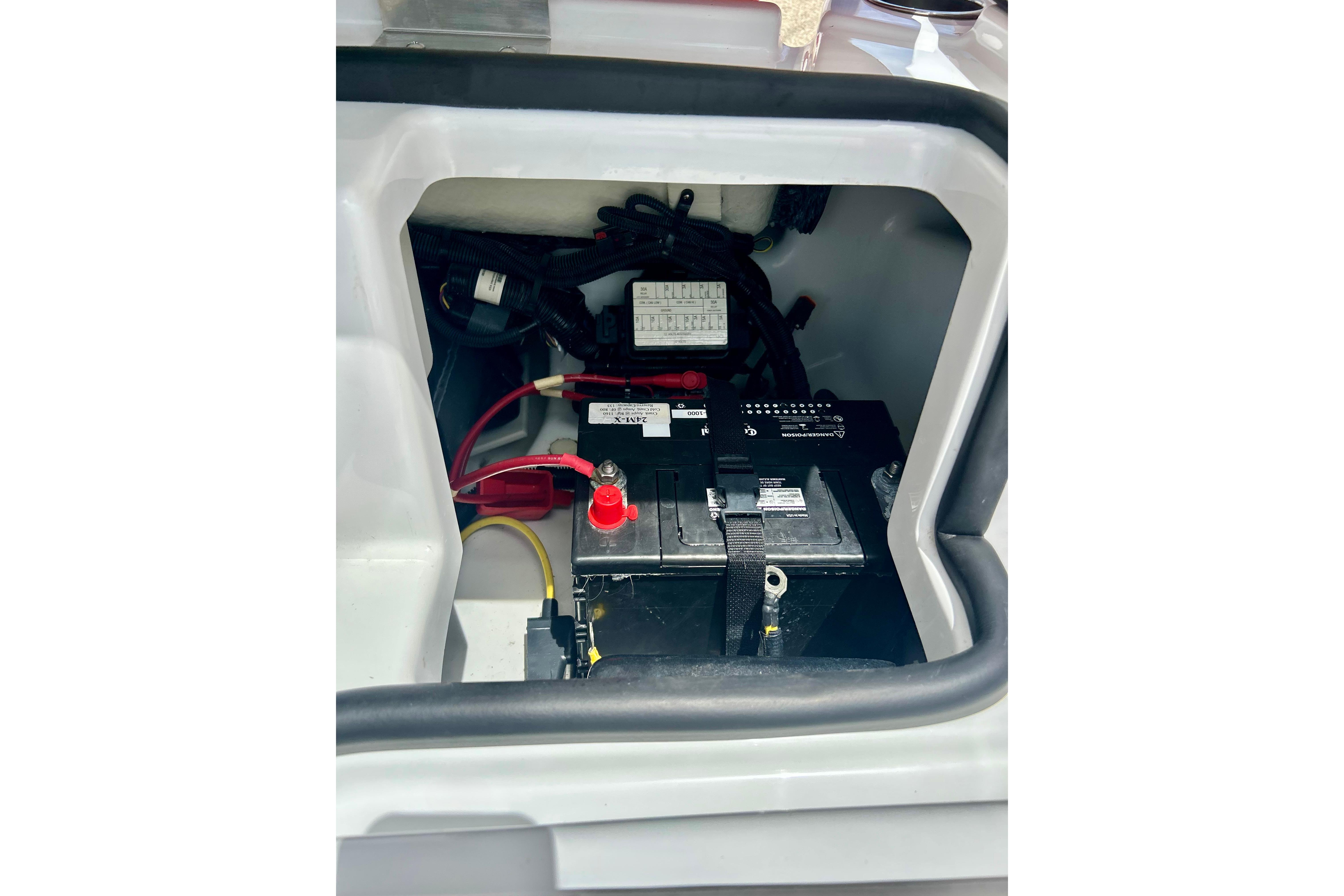 Battery compartment of a 2021 Scarab 195 ID boat, featuring wiring and connections.