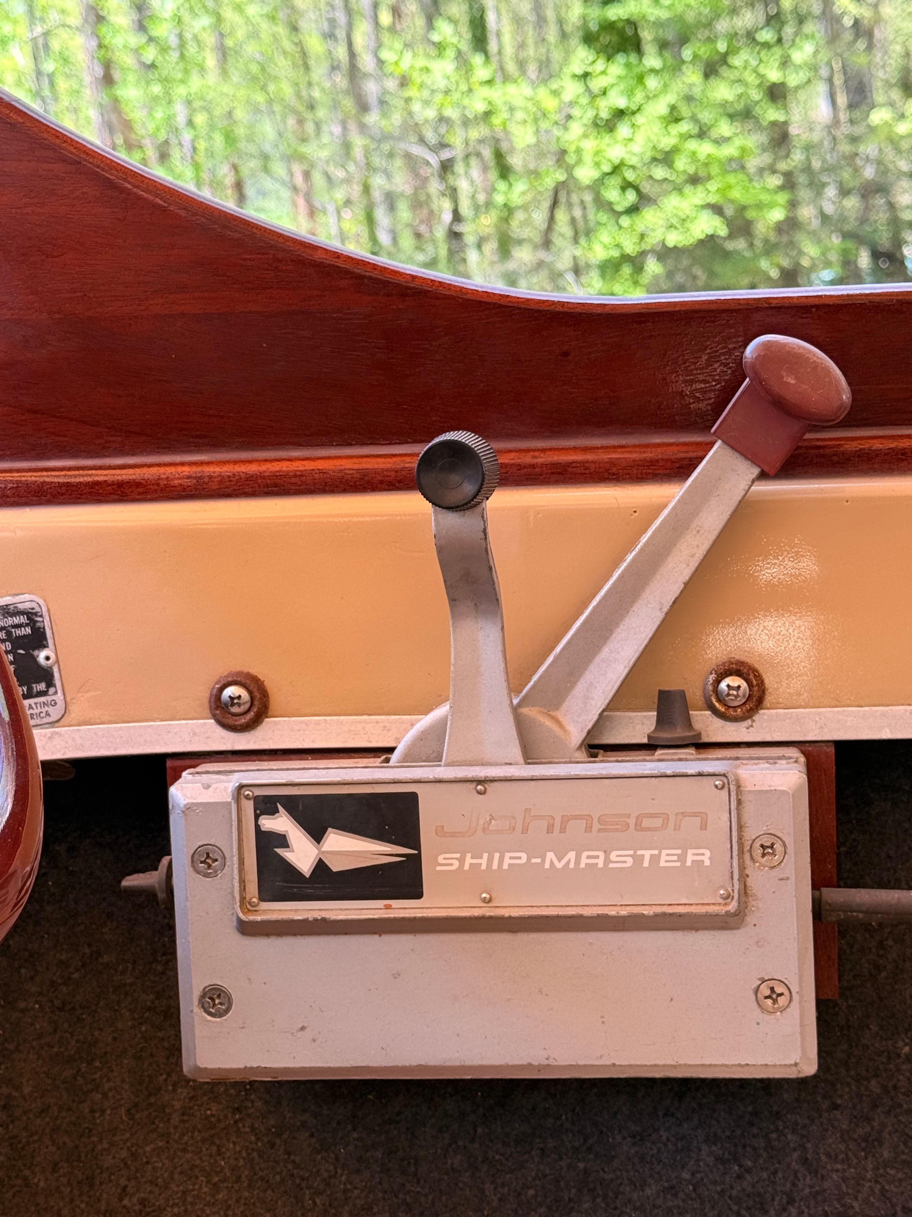 Close-up of a vintage boat throttle lever with wood paneling.