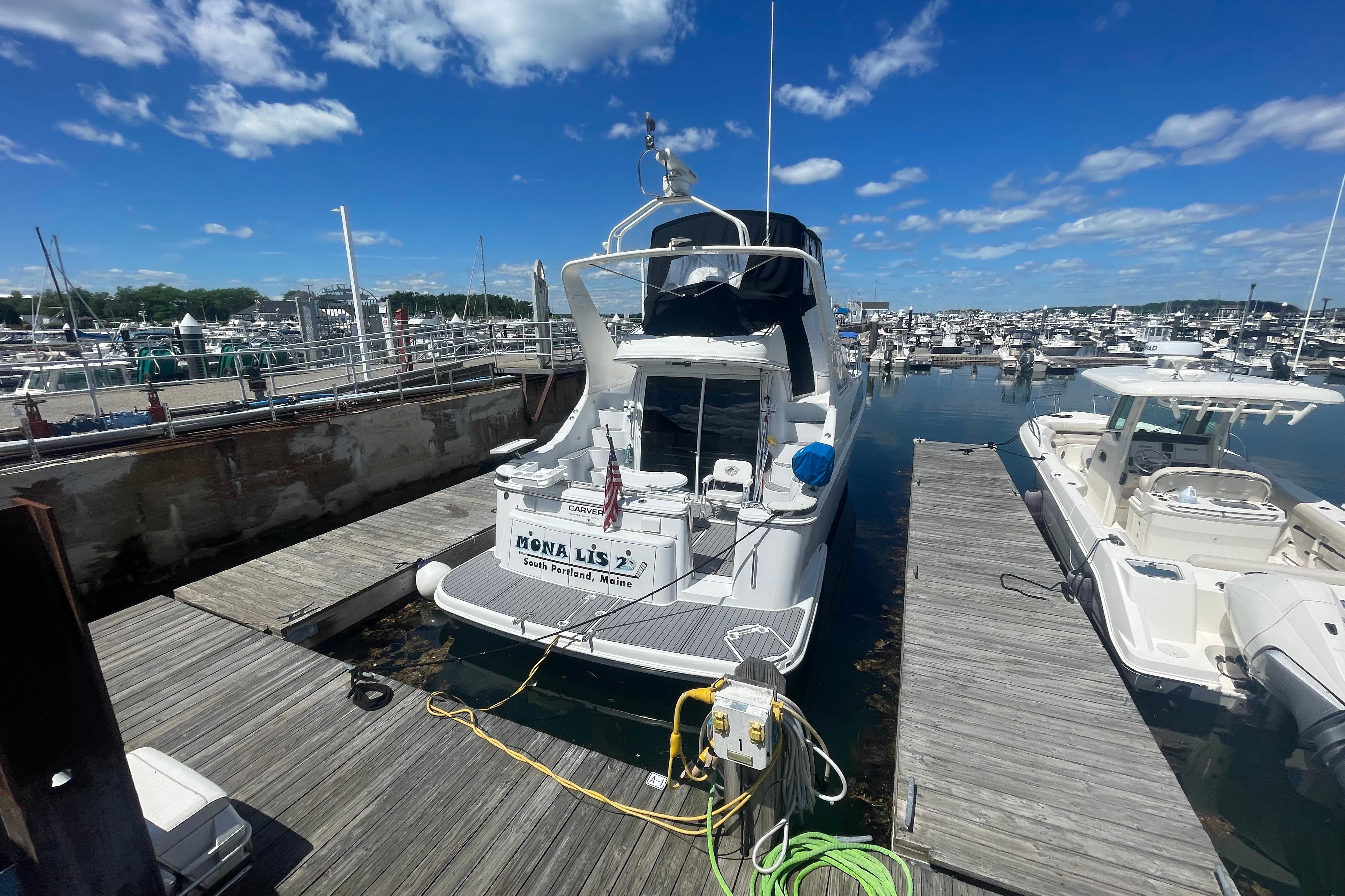 2002 Carver 410 Sport Sedan docked at marina under blue sky.