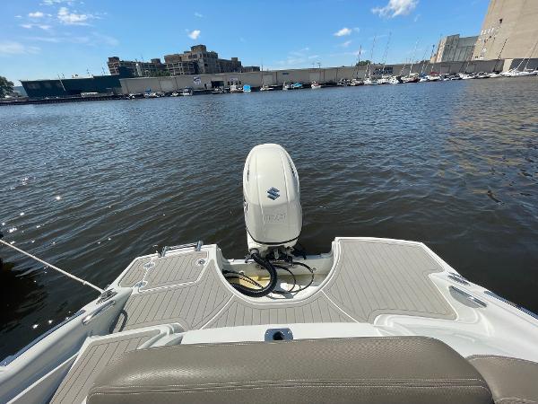 2020 Crownline E 205 XS boat with Suzuki outboard motor on a calm waterfront.
