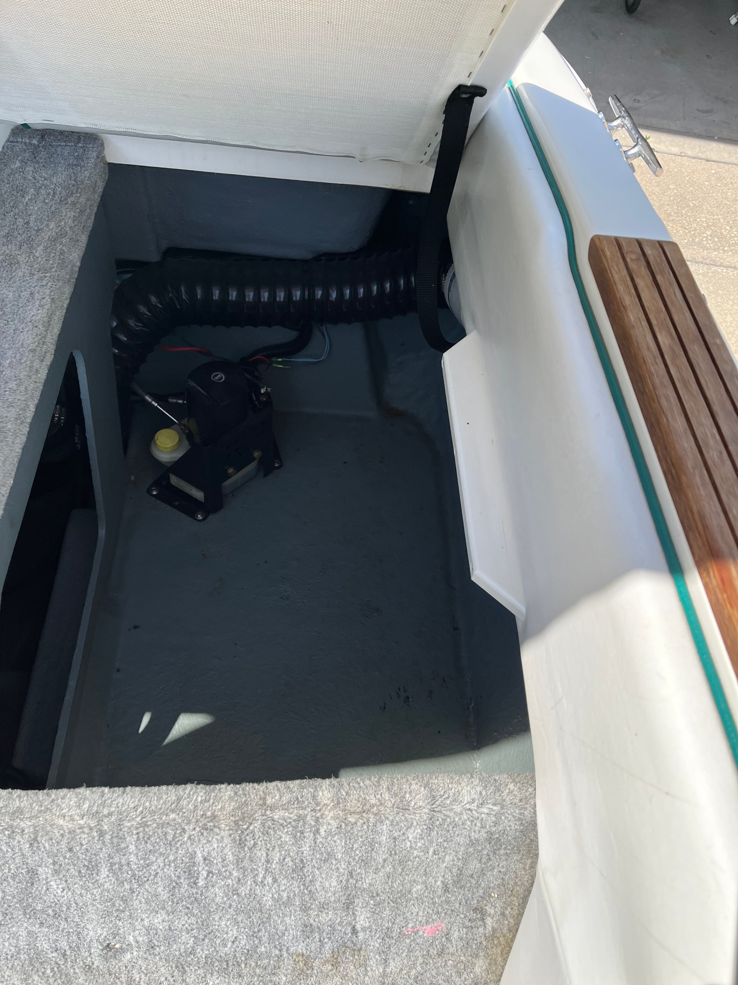 Interior of a Sea Ray 220 Bow Rider boat with gray carpeted flooring.