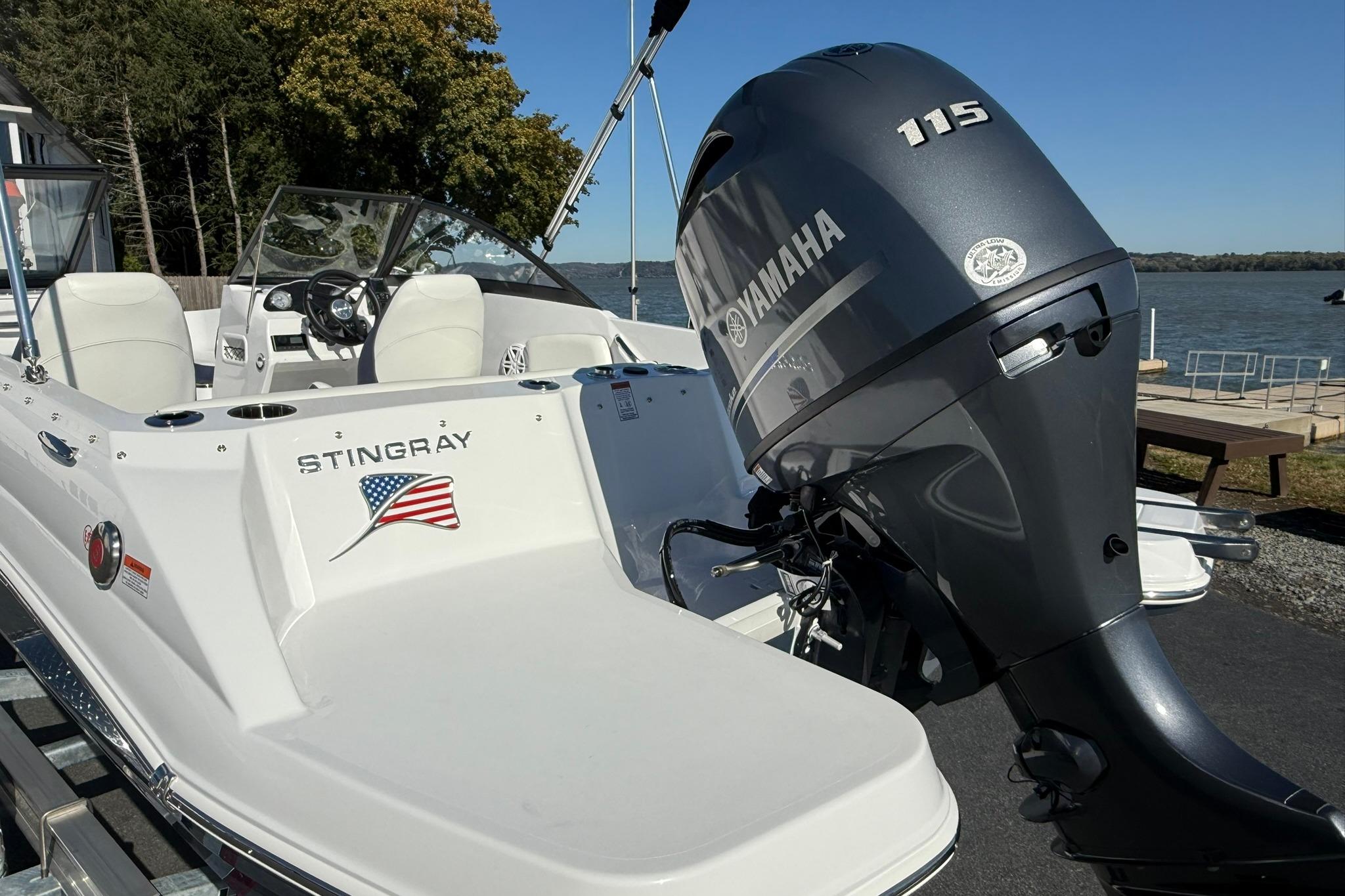 2026 Stingray 191 DC boat with Yamaha 115 engine by a lakeside dock.