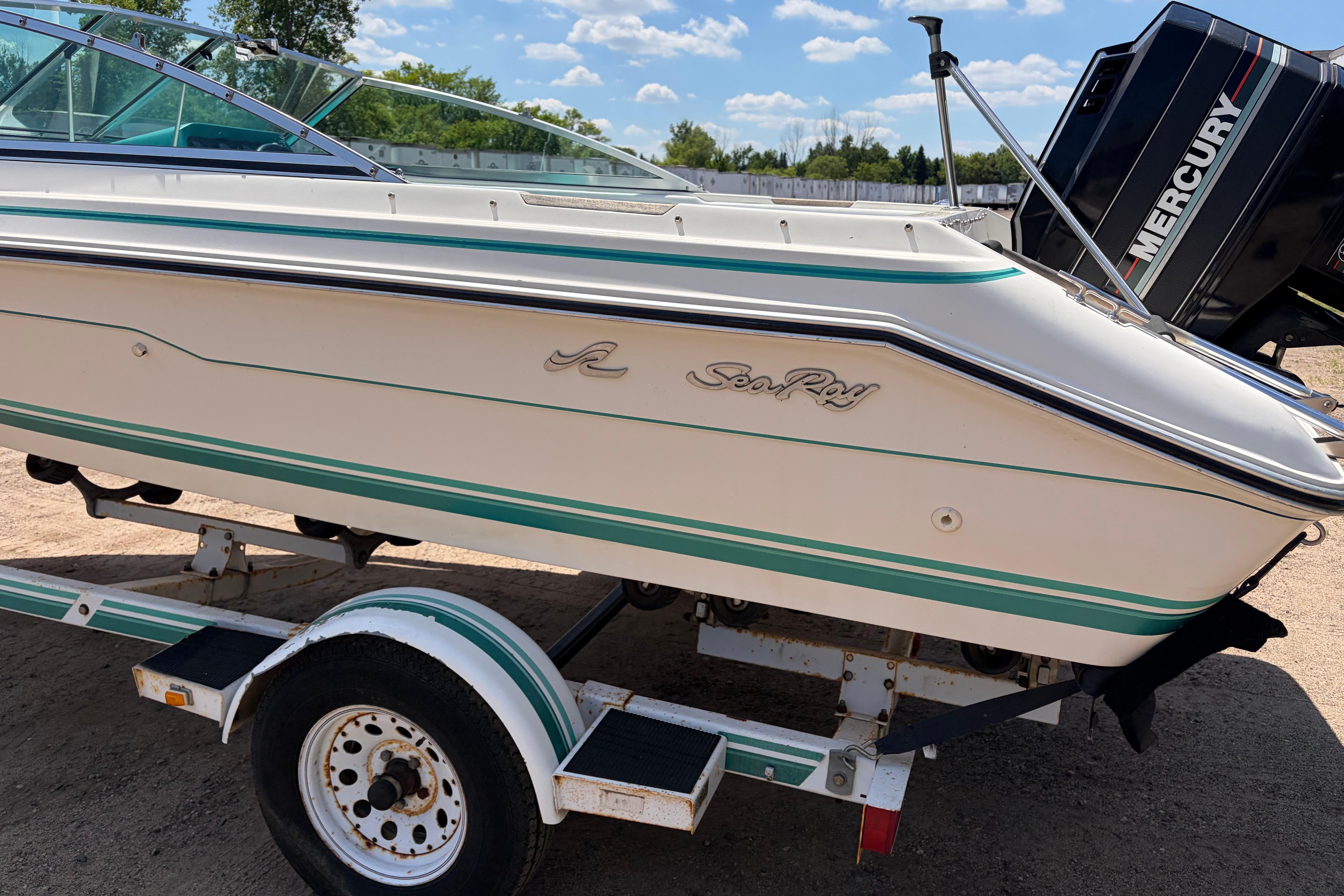 1990 Sea Ray 180 Bow Rider boat on trailer, featuring classic design and Mercury engine.