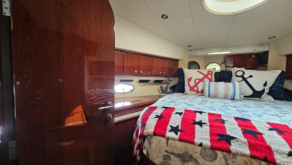 Luxurious 2005 Neptunus 56 Flybridge yacht bedroom with nautical-themed decor.