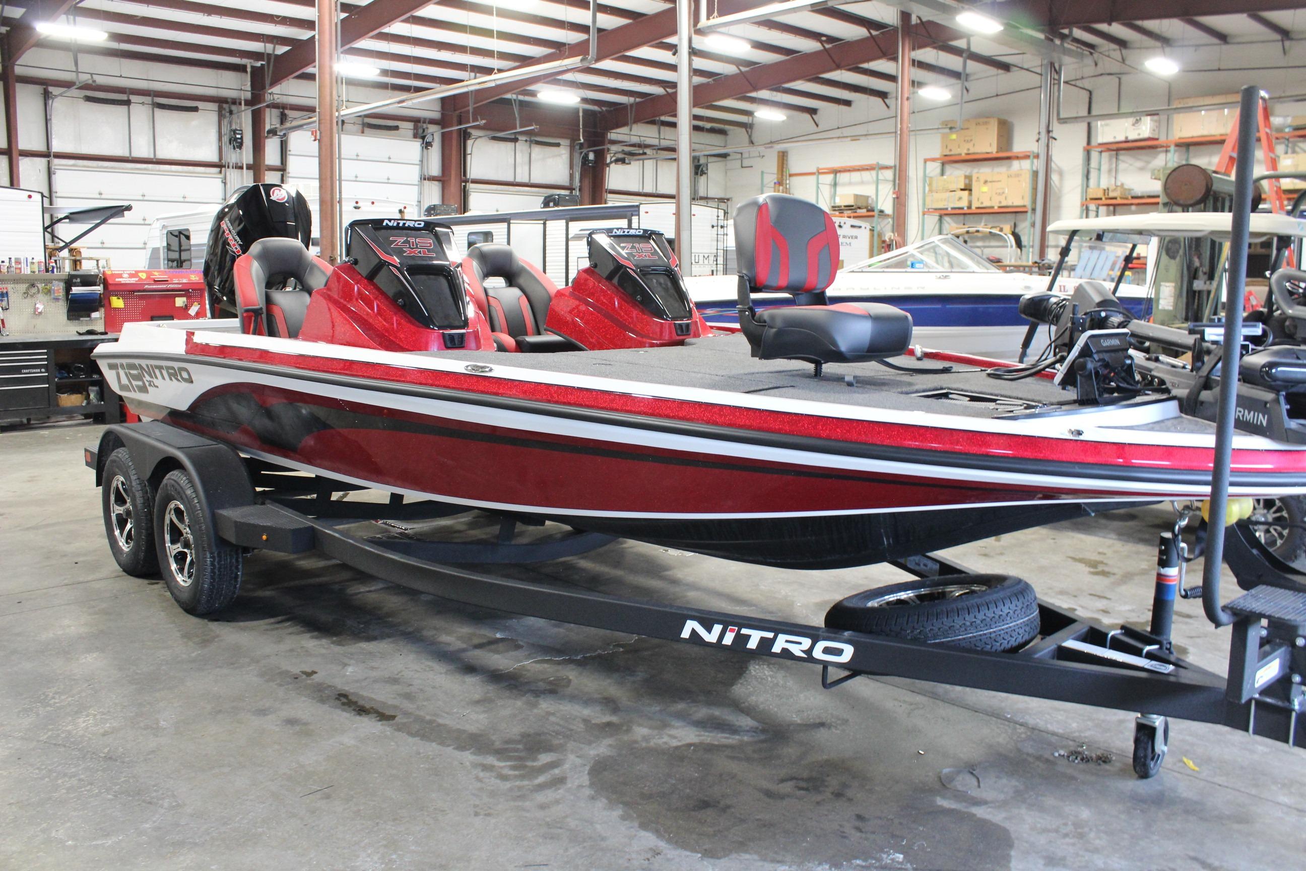 2026 Nitro Z19 XL Pro bass boat in a showroom, featuring a sleek red design.