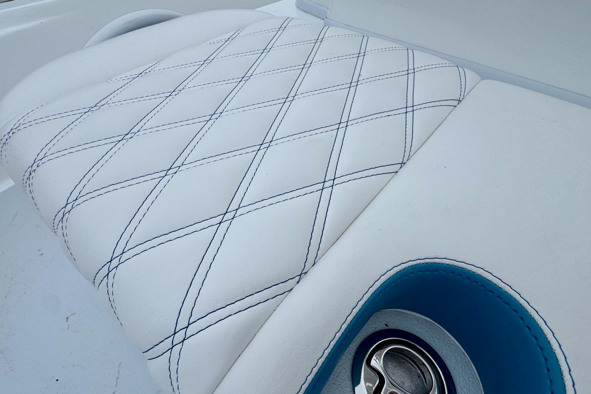Luxurious white leather seat with blue stitching in 2026 Shallow Sport 24 Modified V boat.
