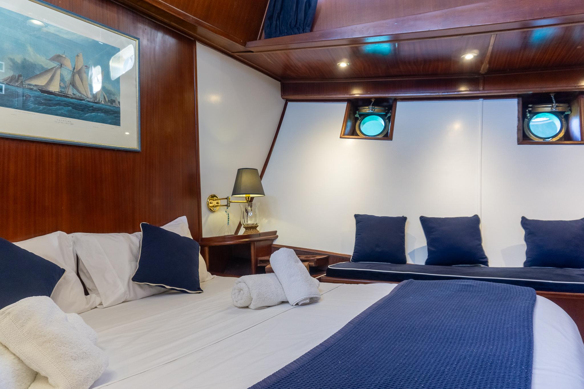 Luxurious cabin interior of a 1969 Psarros Shipyard yacht with elegant bedding and decor.
