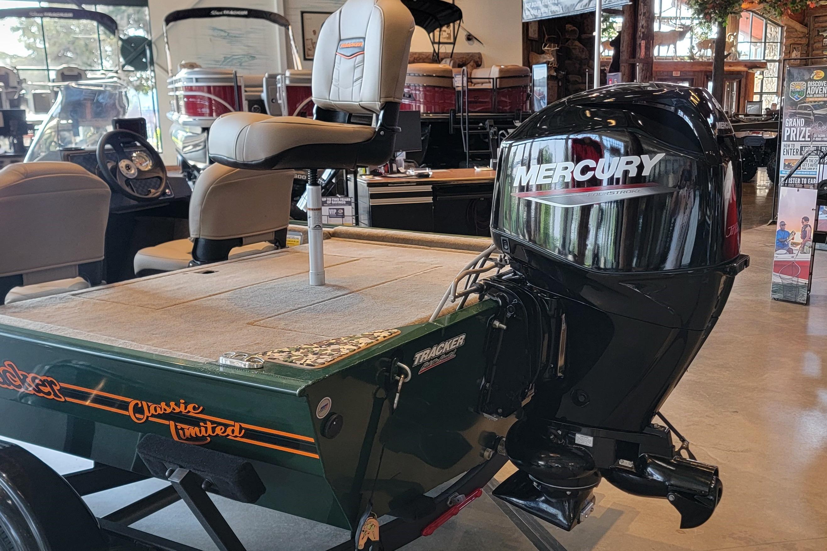 2026 Tracker Bass Tracker Classic Limited boat with Mercury outboard motor in showroom.