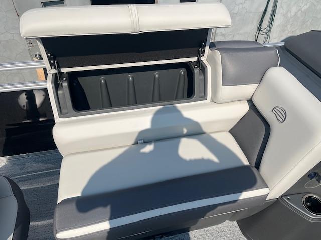 2026 Sun Tracker Fishin' Barge 20 DLX boat seat with open storage compartment.