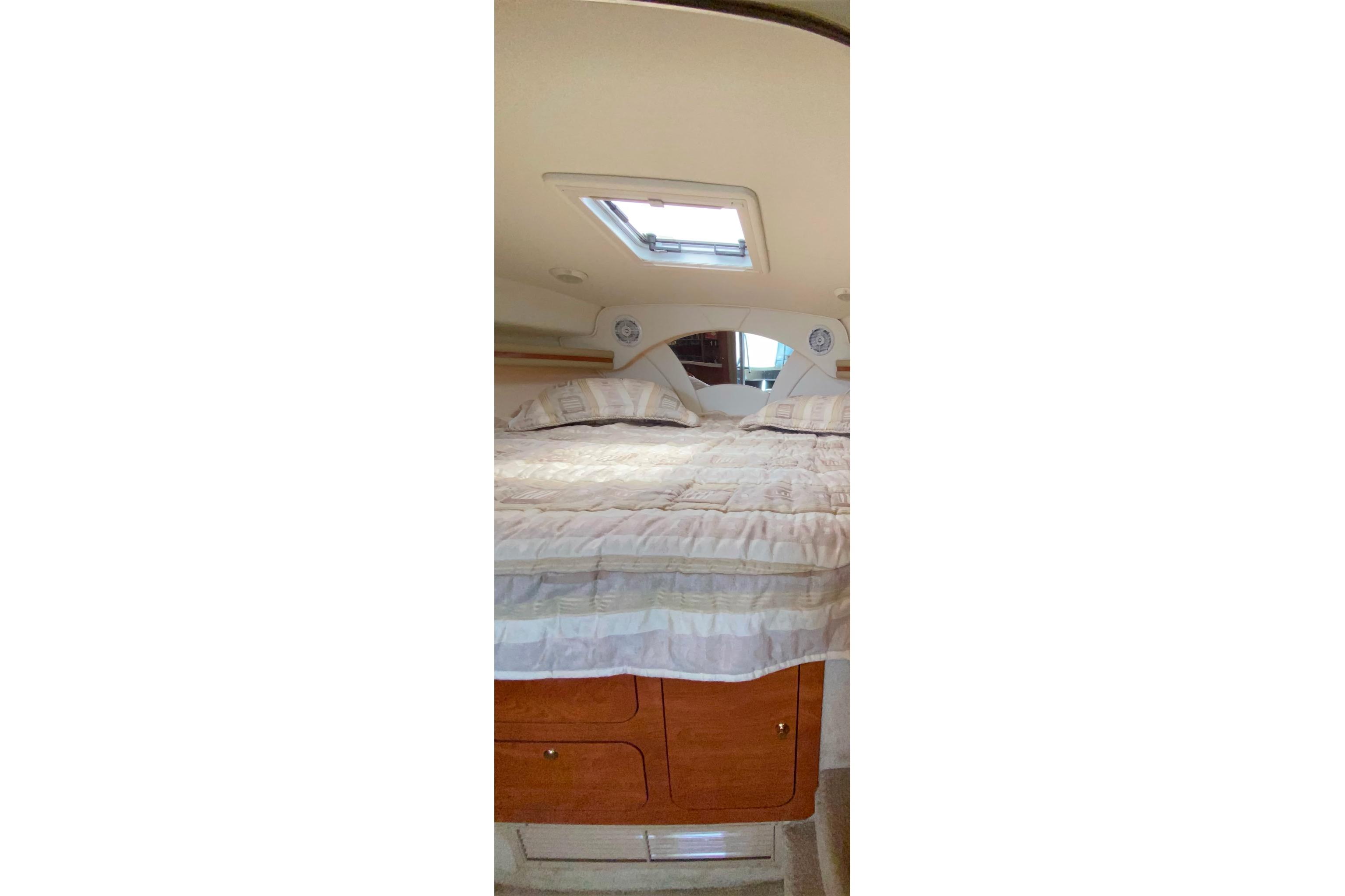 Interior cabin of 2003 Rinker Fiesta Vee 342 with bed and skylight.