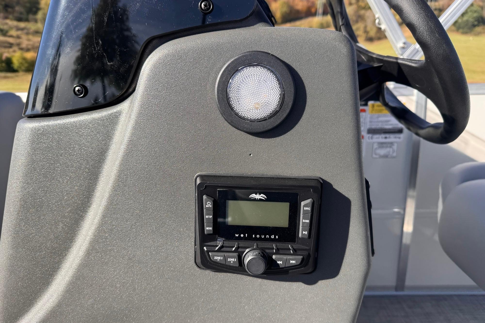 2026 Sun Tracker Party Barge 16 DLX dashboard with audio controls and speaker.