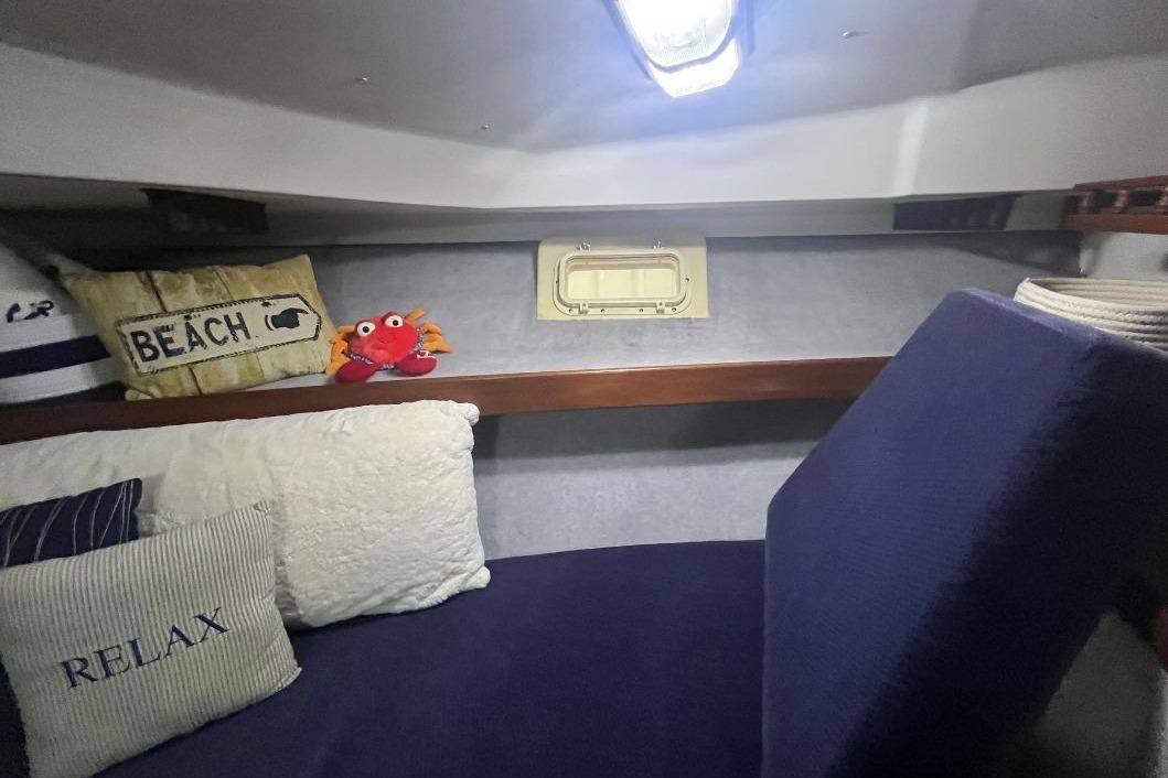 1976 Uniflite 32 Sport Sedan cabin with nautical-themed pillows and cozy seating.