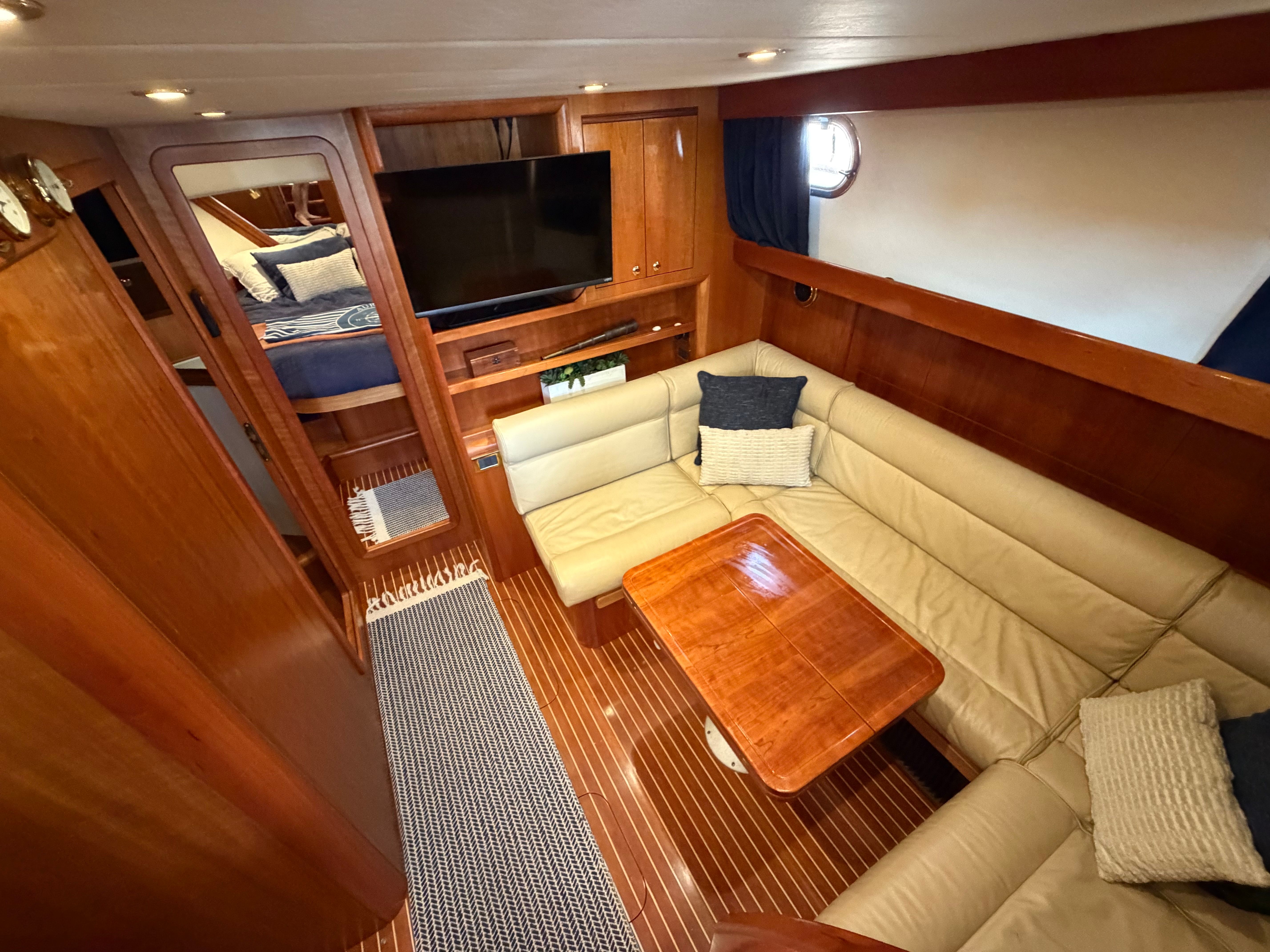 Interior of a 2003 Apreamare 11 with a cozy seating area and wooden table.
