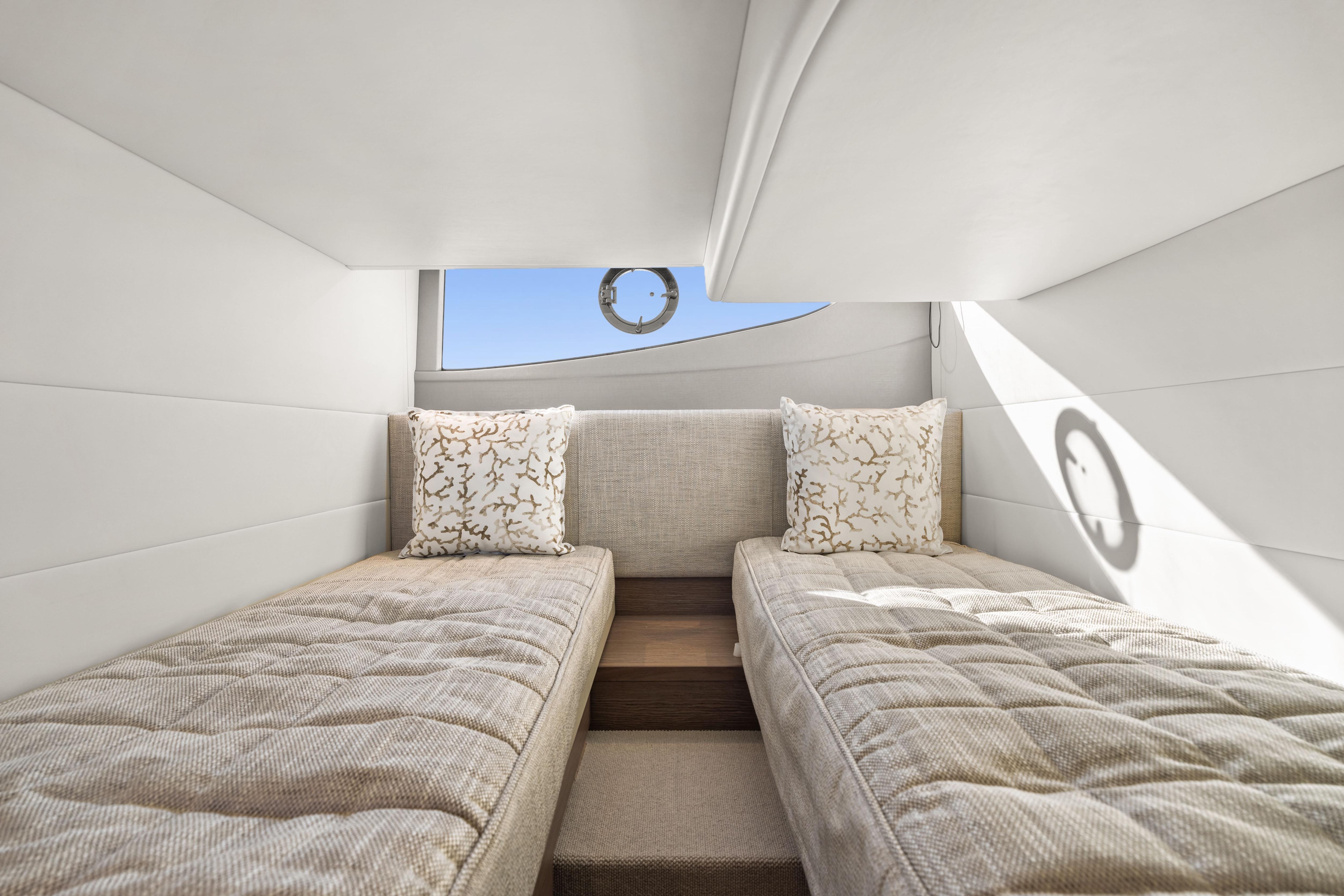Luxurious twin cabin interior of 2025 Princess V40 yacht, featuring elegant bedding and decor.