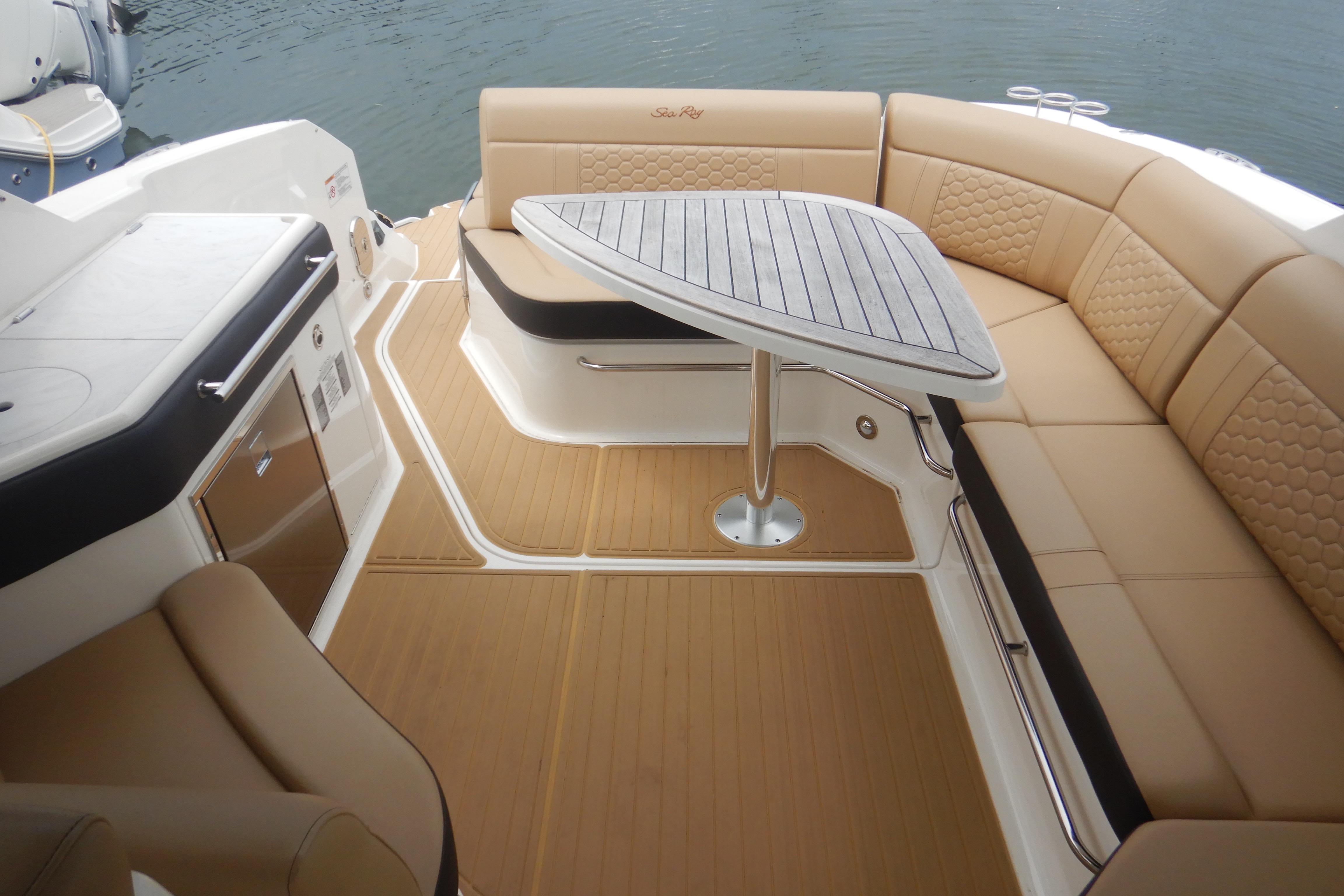 Luxurious 2023 Sea Ray Sundancer 320 boat interior with elegant seating and table.