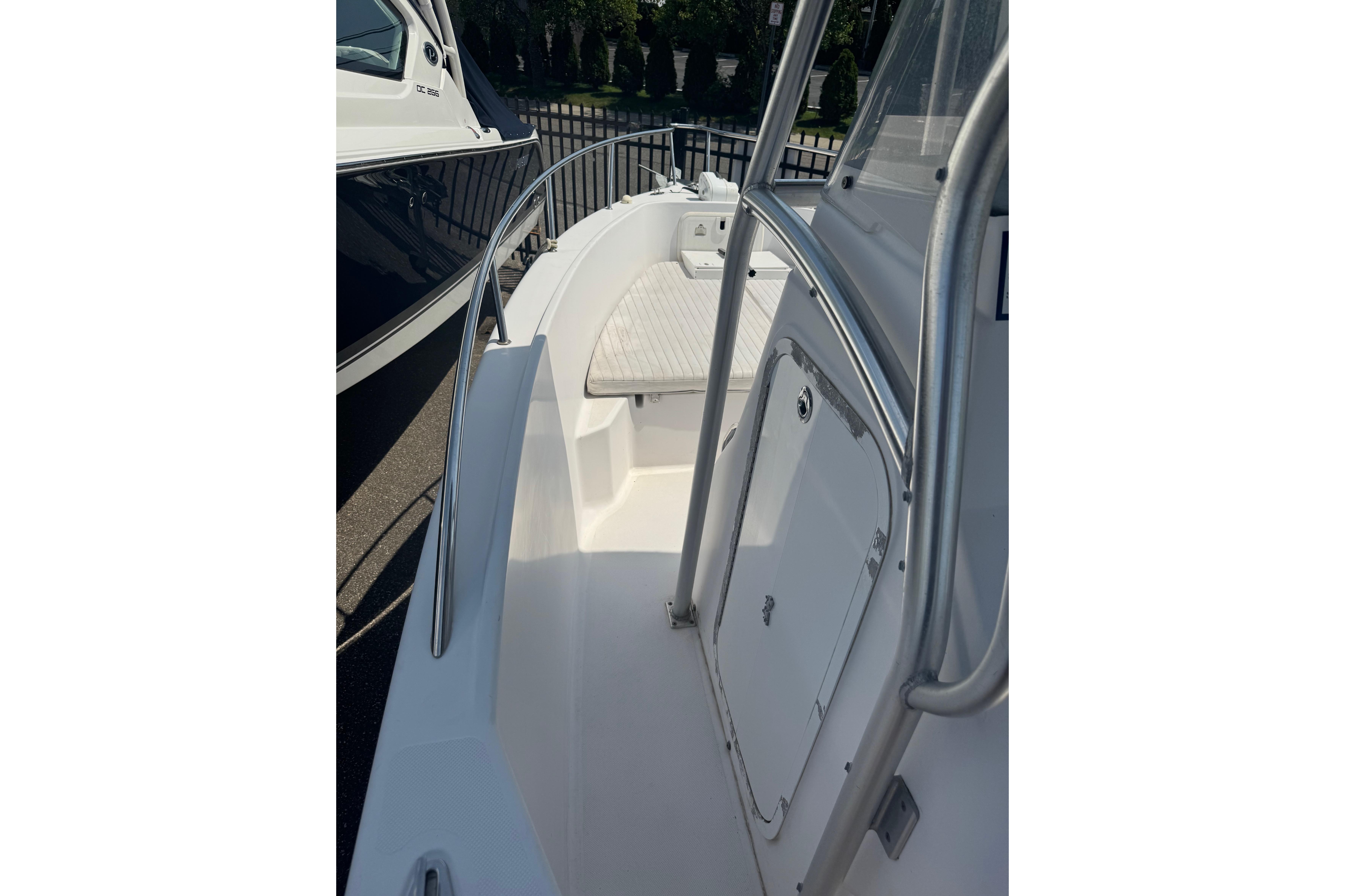 2002 Pro-Line 23 Sport boat deck with stainless steel railings and storage compartment.