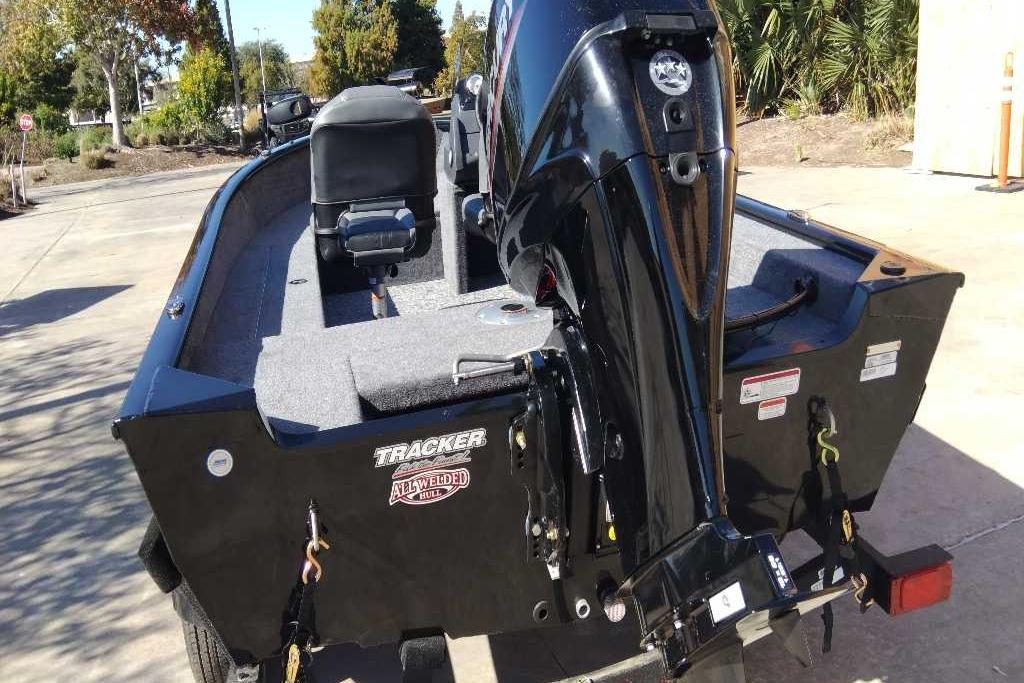 2026 Tracker Super Guide V-16 SC boat with motor, parked outdoors.