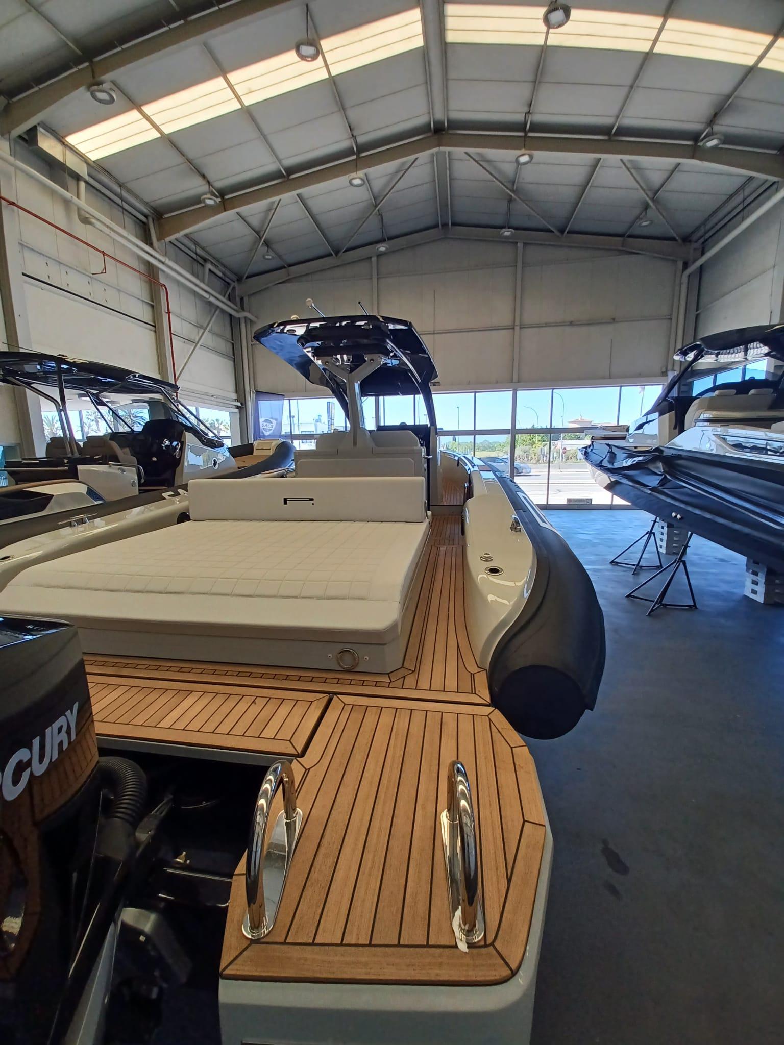 2025 Pirelli PIRELLI 35 boat in showroom, featuring sleek design and wooden deck.