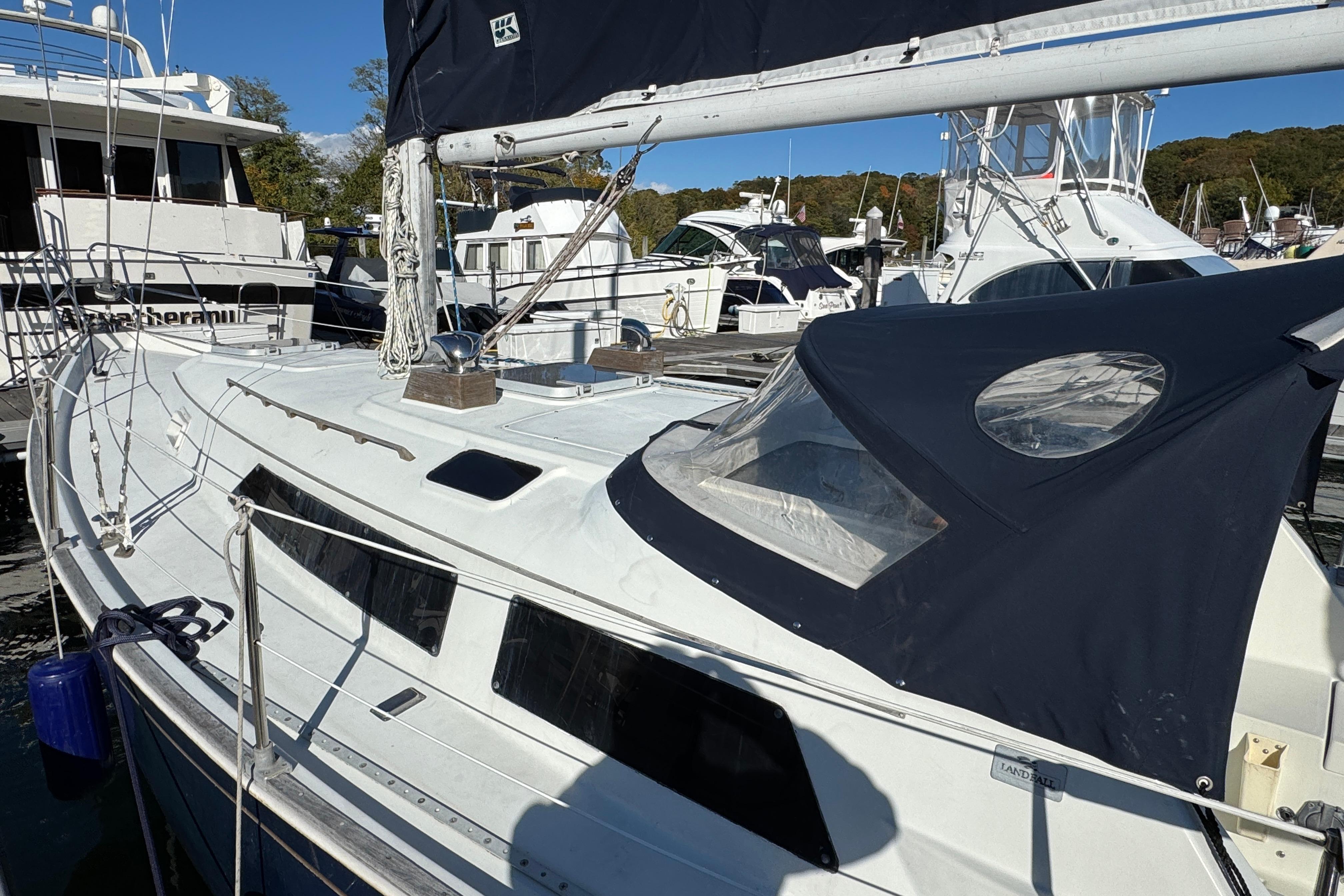 1984 C&C Landfall sailboat docked at marina, featuring sleek design and dark canopy.