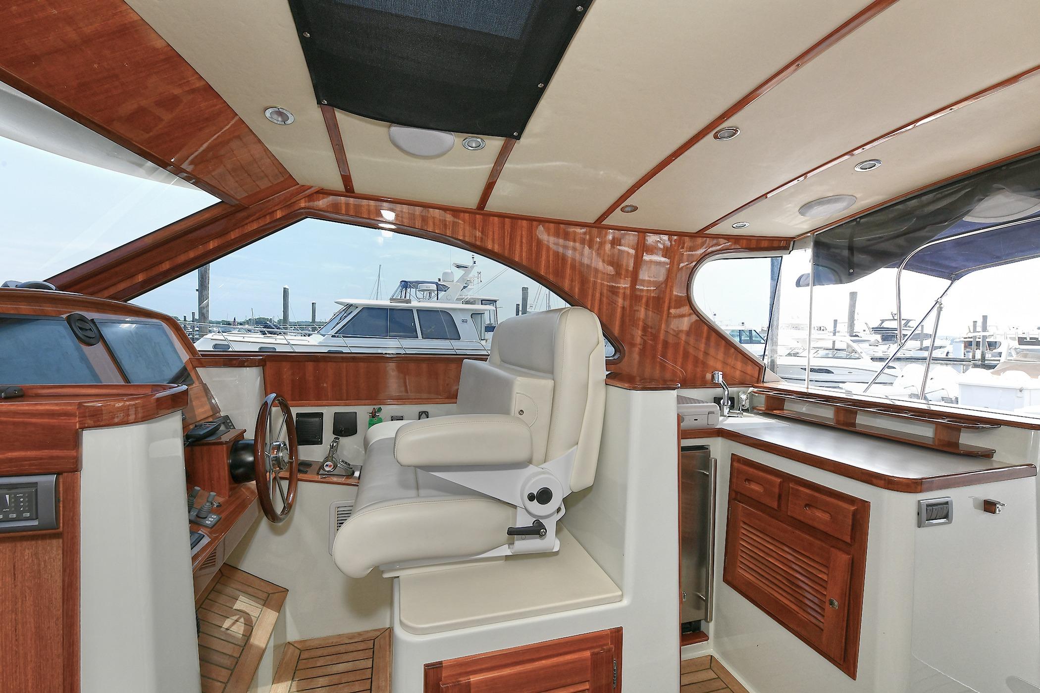 Luxurious 2005 San Juan Downeast Express yacht interior with wood accents and helm station.