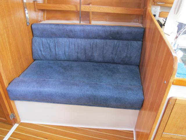 Interior of a 2000 Catalina 310 yacht with blue upholstered bench.