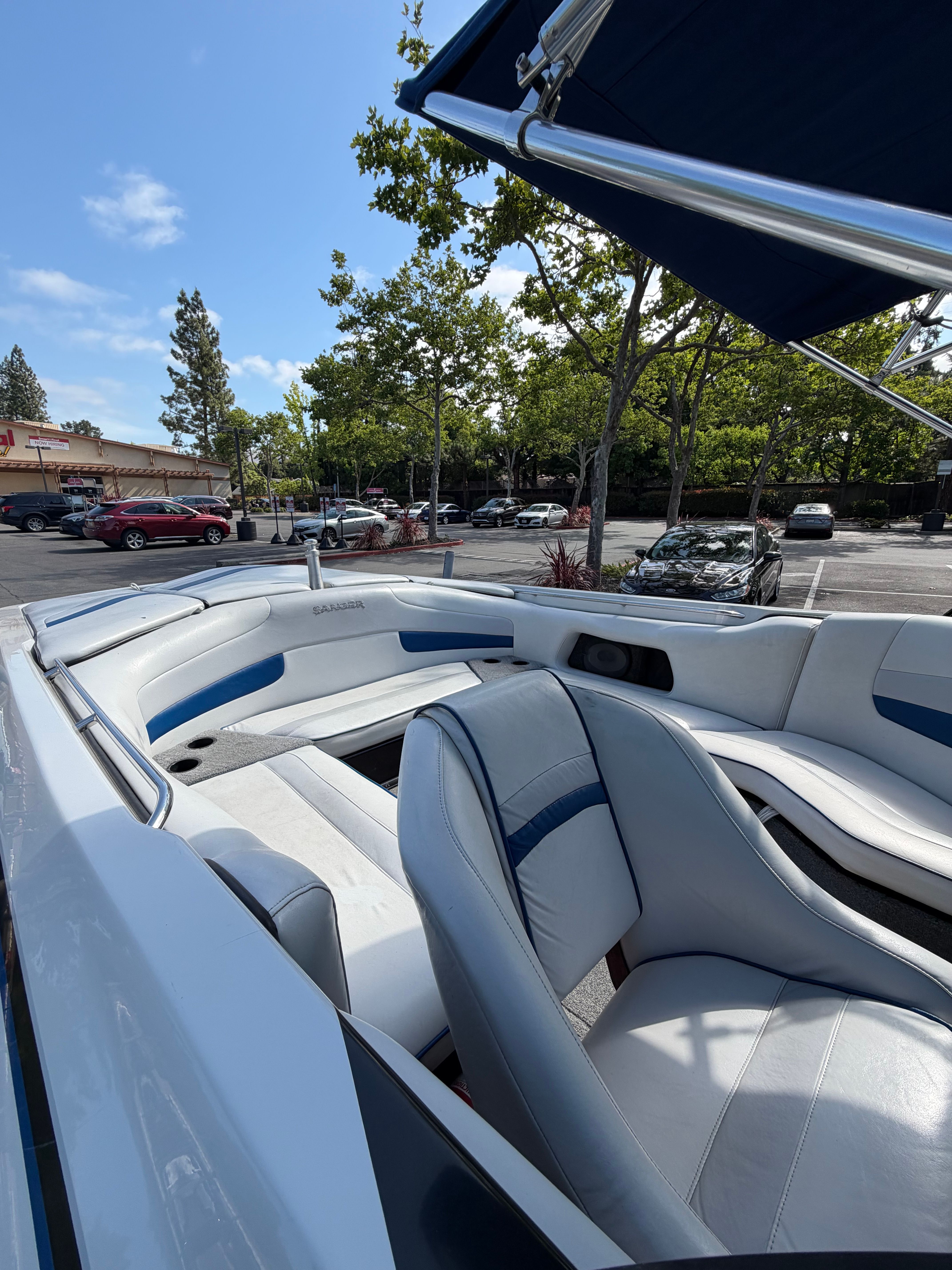 Interior view of a 2001 Sanger V210 with white and blue seats, parked in a lot.