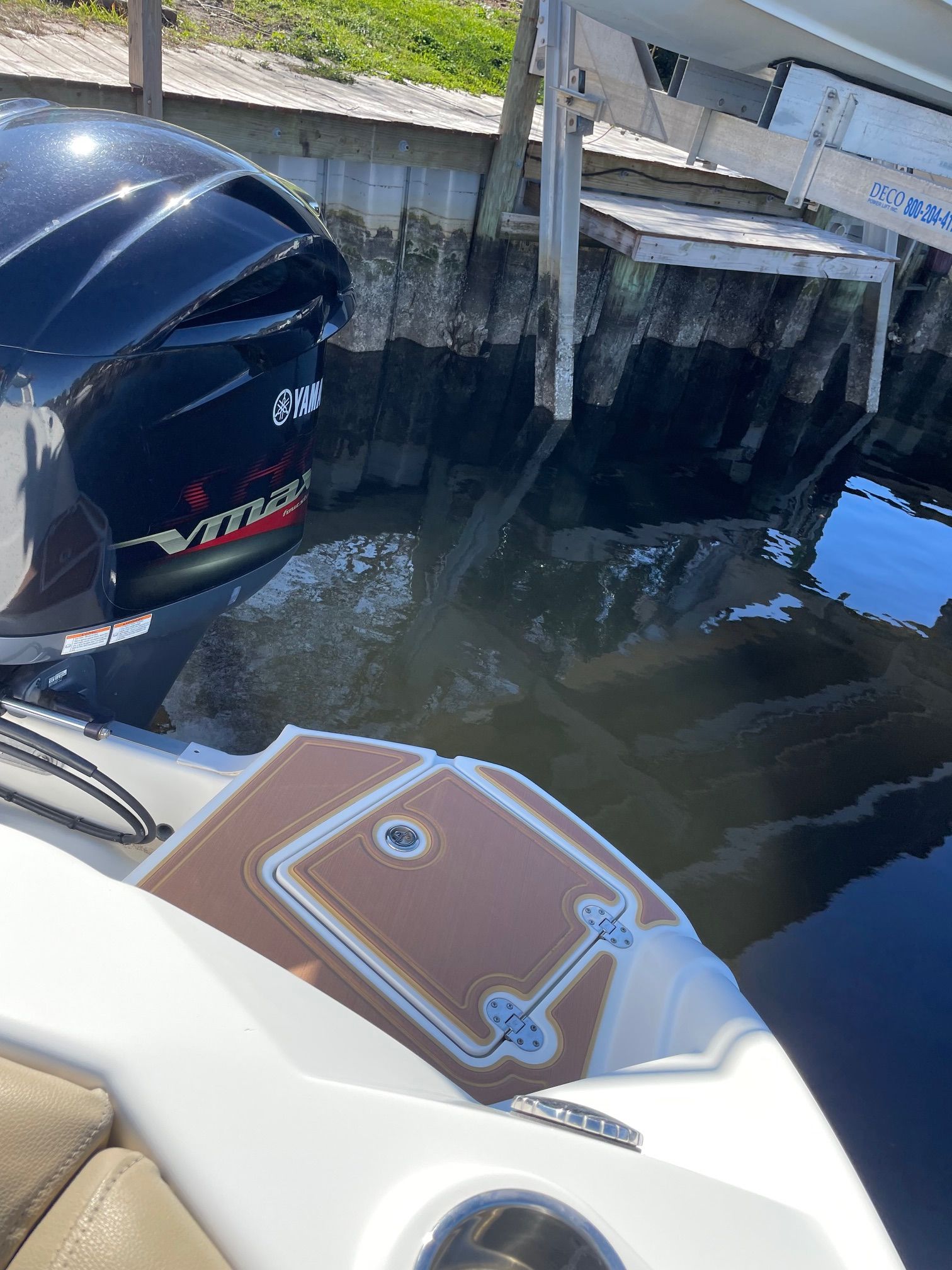 A 2019 NauticStar 243DC Sport Deck boat by the water with a Yamaha outboard motor.