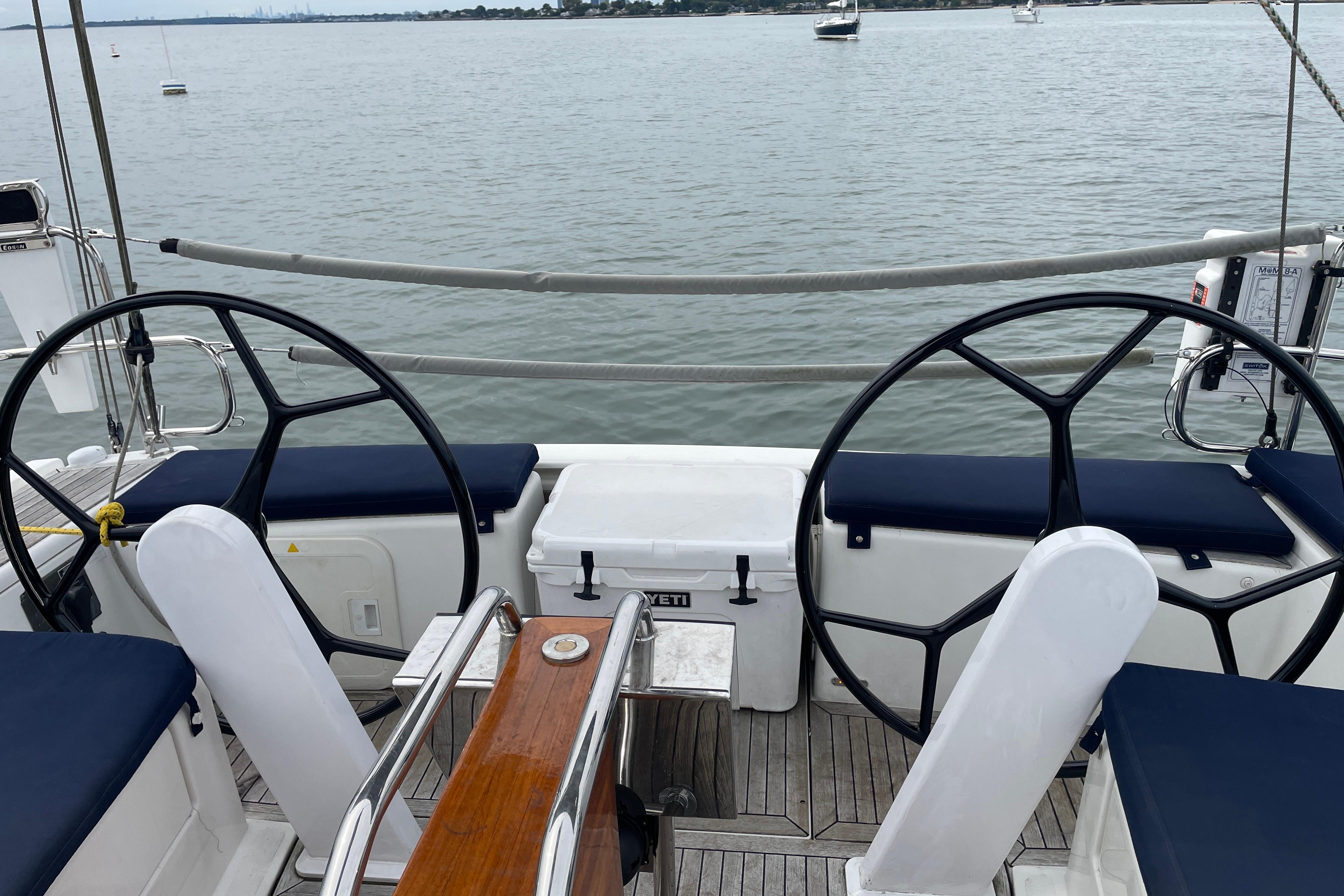 Cockpit of 2014 Hanse 415 sailboat with dual steering wheels and ocean view.