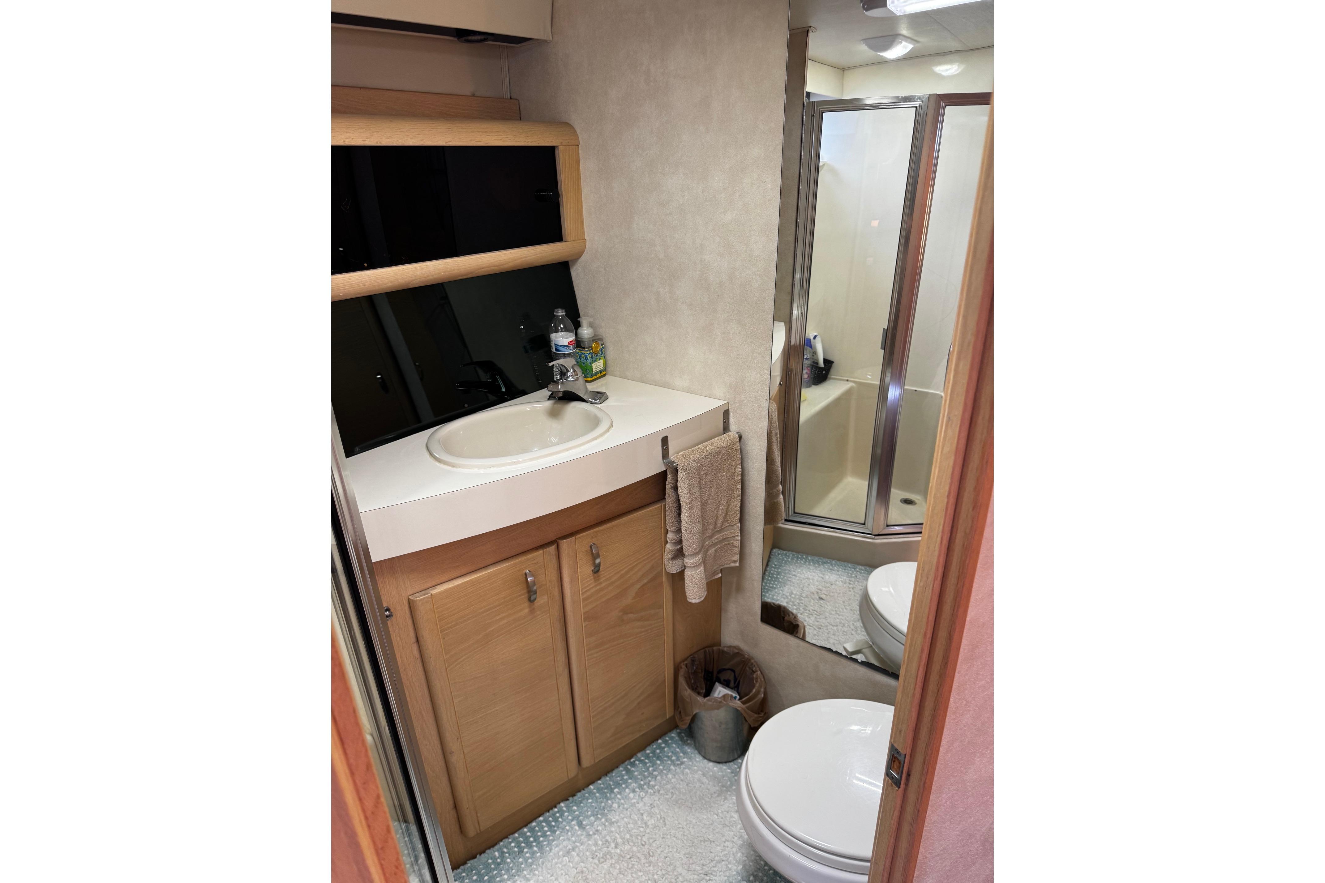 Bathroom interior of 1991 Silverton 46 Motor Yacht with sink, shower, and toilet.