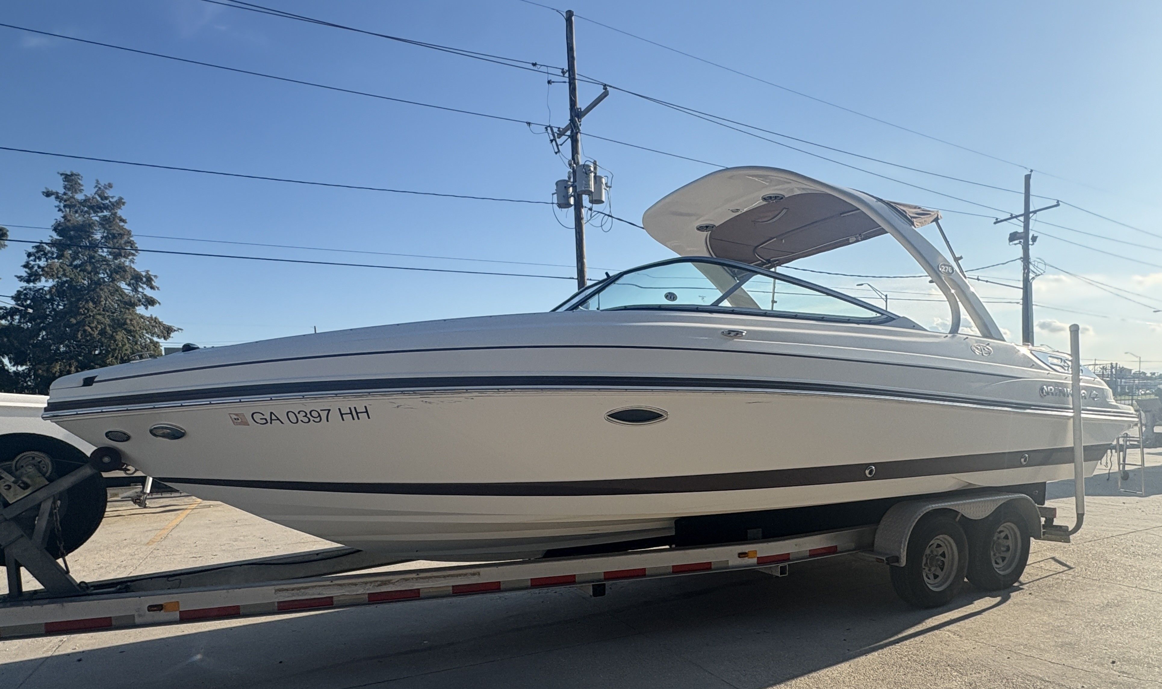 2013 Rinker Captiva 276 boat on trailer under clear sky.