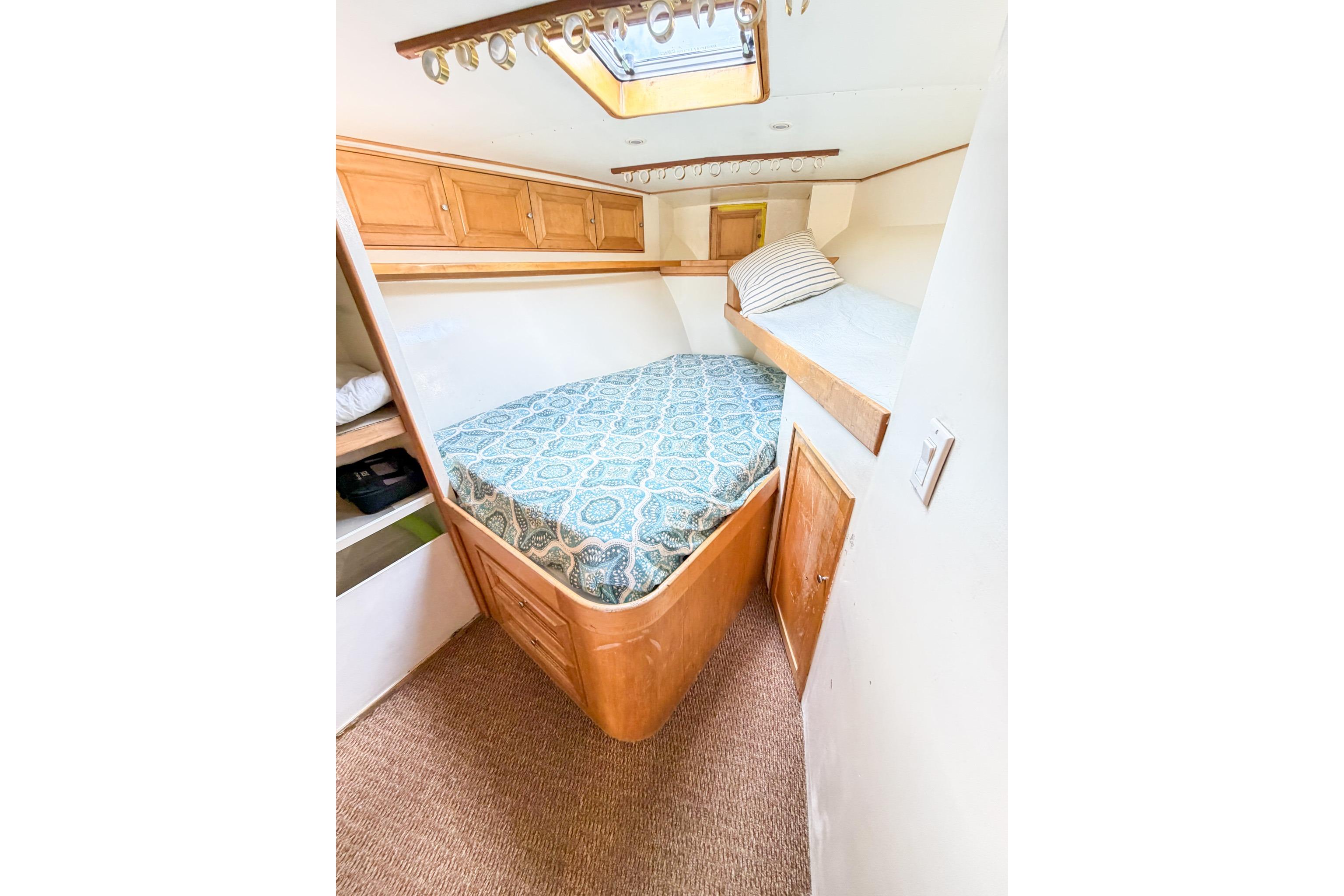 1998 Blackwell Custom Carolina Sportfish cabin with cozy beds and wooden storage cabinets.