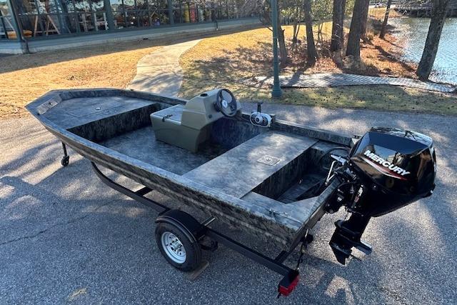 2026 Tracker Grizzly 1648 SC boat with Mercury engine on a trailer by a lakeside.