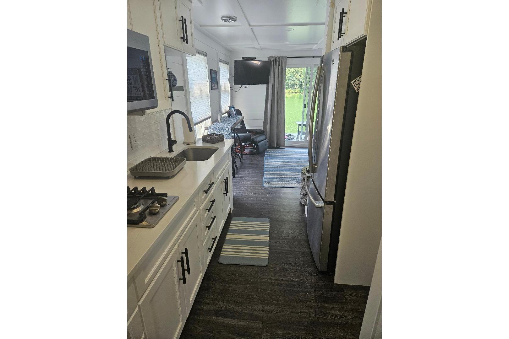 Modern kitchen interior of 2021 East Coast Houseboats Freedom 40, featuring sleek appliances and cozy decor.