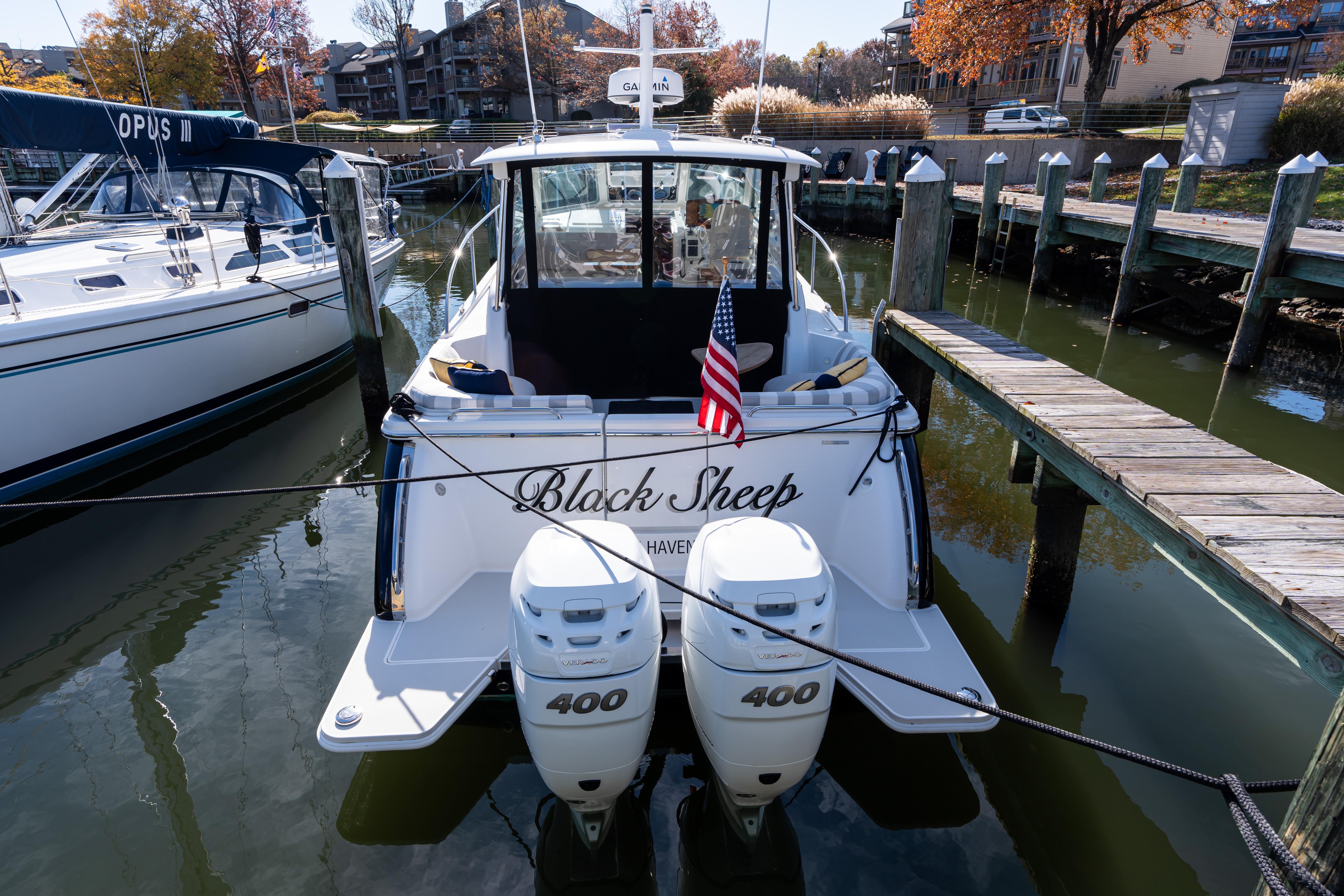 2023 Back Cove 340 boat docked, displaying twin 400 engines and American flag.