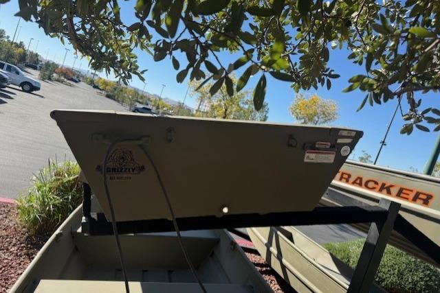 2026 Tracker Grizzly 10 Jon boat displayed outdoors under tree branches.