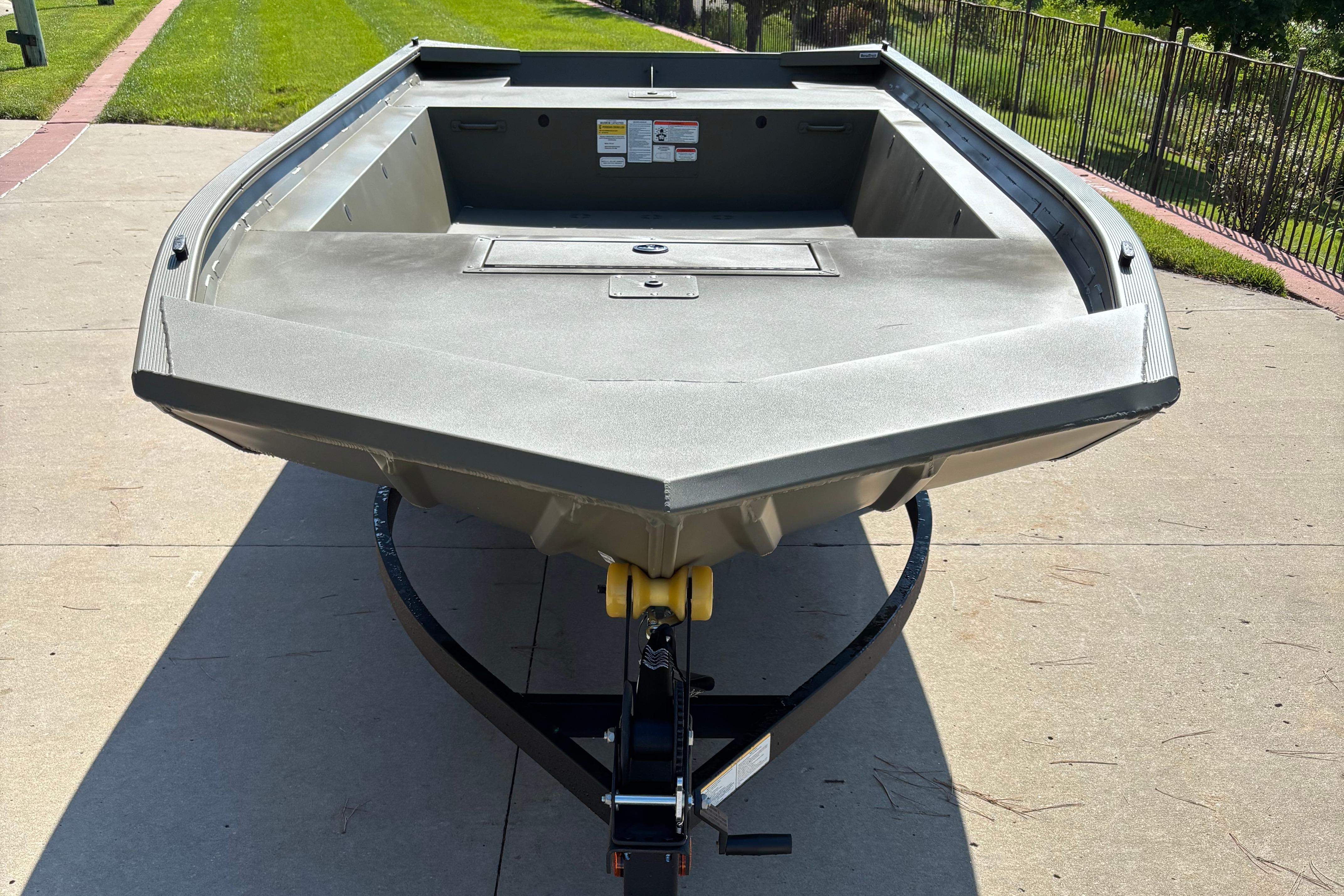 2026 Tracker Grizzly 1754 Utility boat on trailer, parked on concrete driveway.