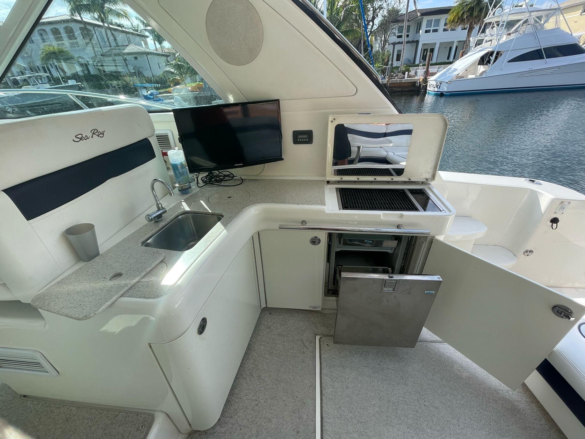 Interior of a 2010 Sea Ray 450 yacht with kitchenette and TV.