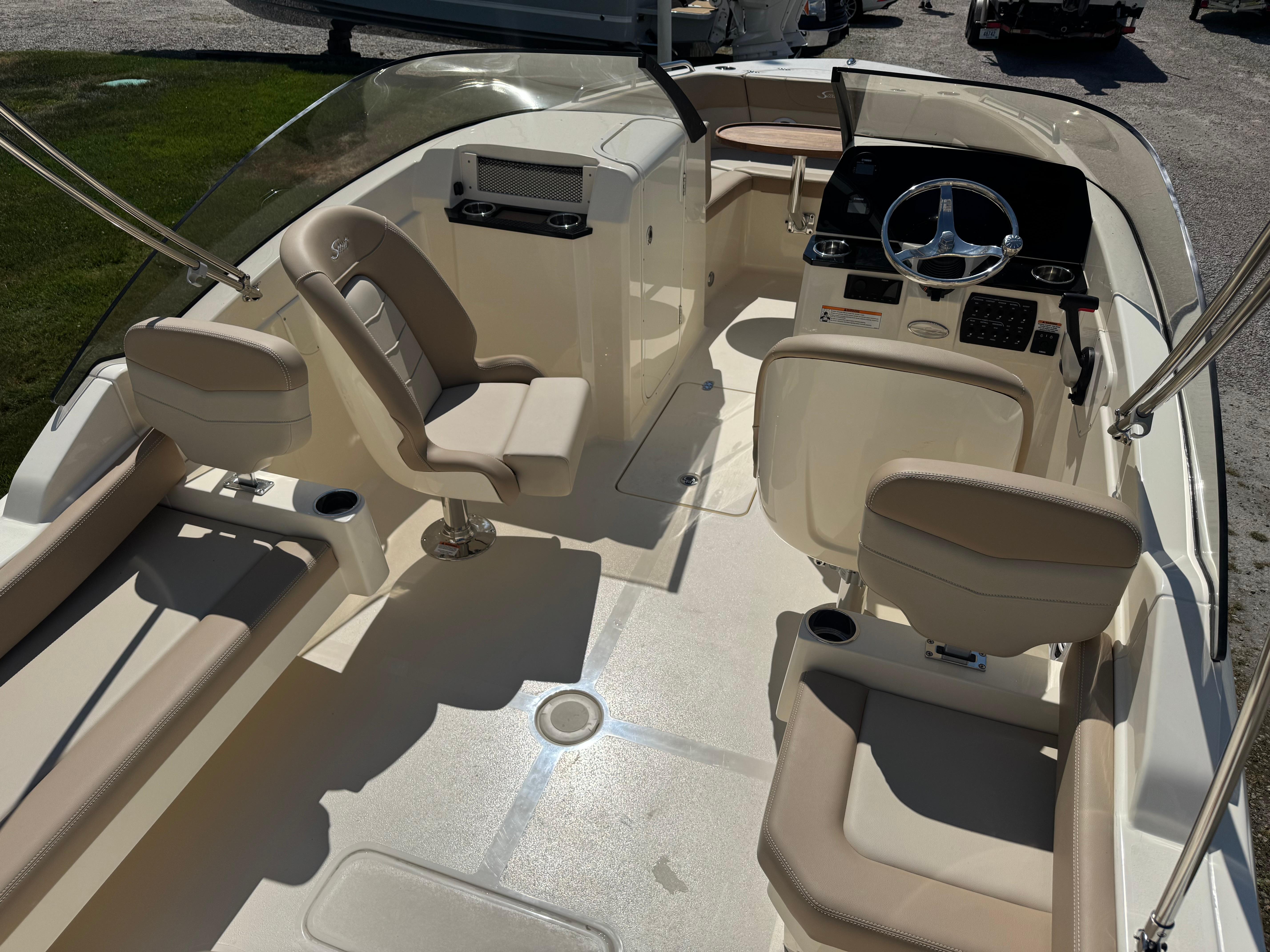2025 Scout 215 Dorado boat interior with beige seating and modern steering console.