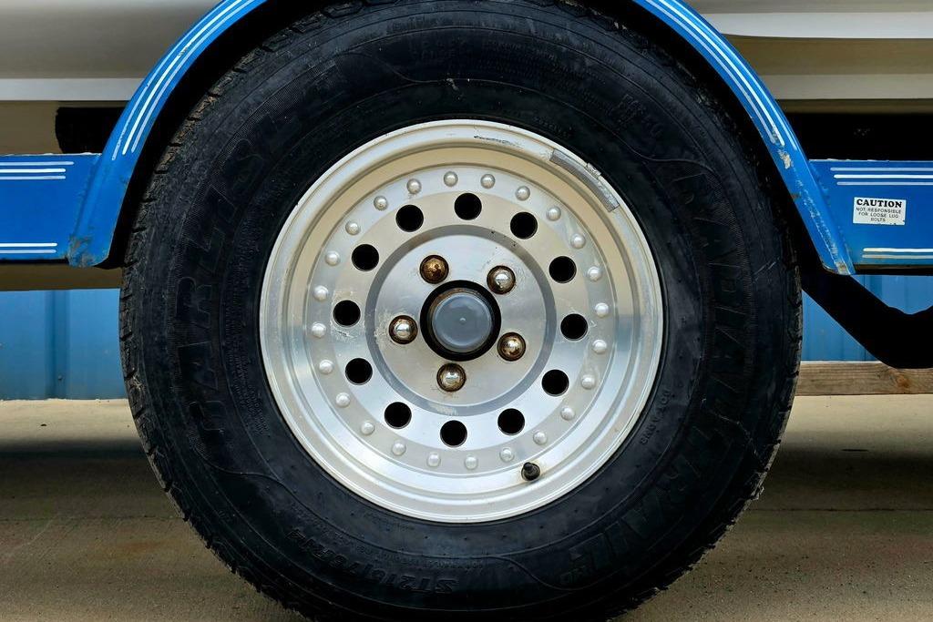 Close-up of a 1996 Champion 181 SX trailer wheel with blue fender.