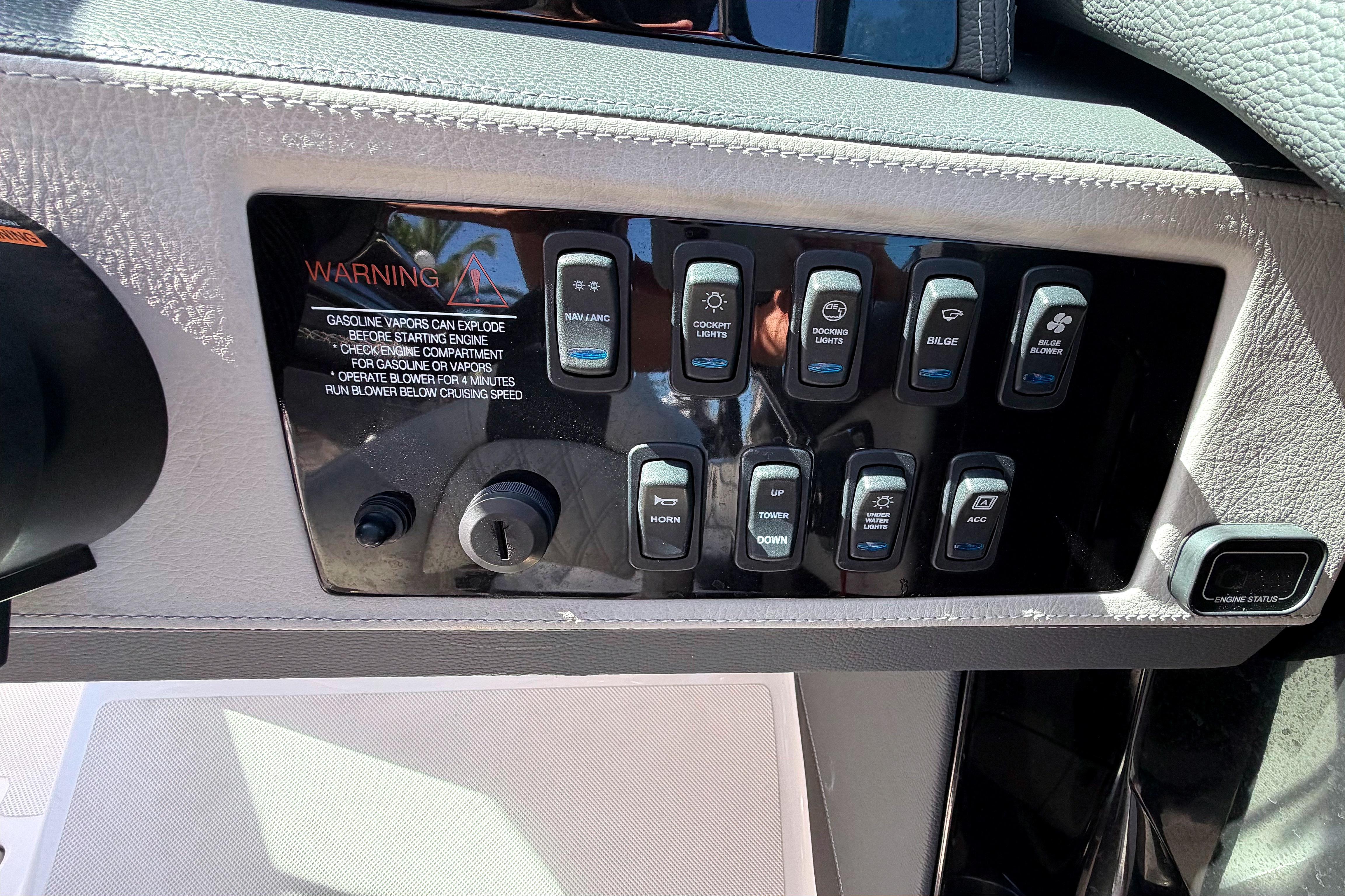 Control panel of a 2020 Regal 2300 Bowrider boat with various switches and warning label.