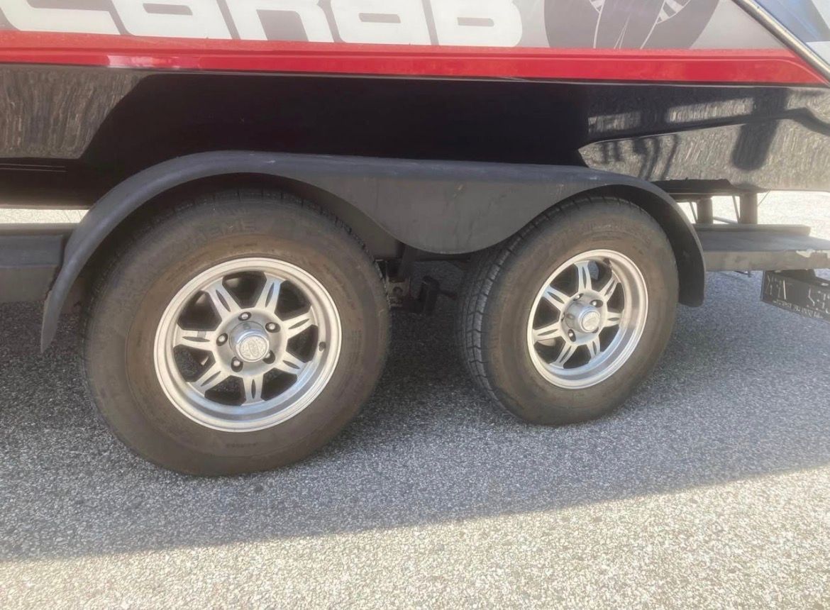 Close-up of a boat trailer with two wheels on asphalt.