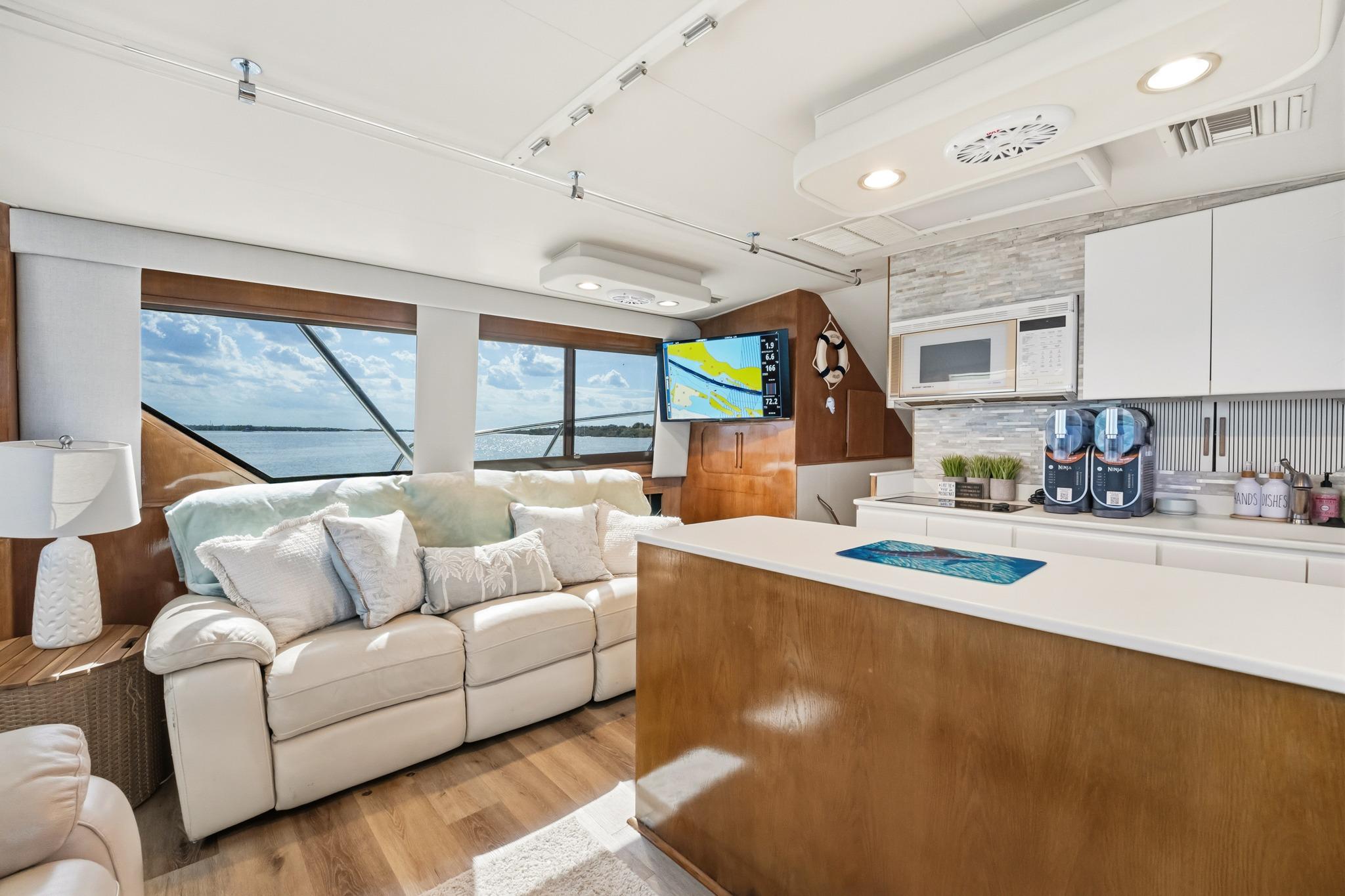 Luxurious interior of 1995 Hatteras 50 Convertible yacht with modern kitchen and scenic windows.