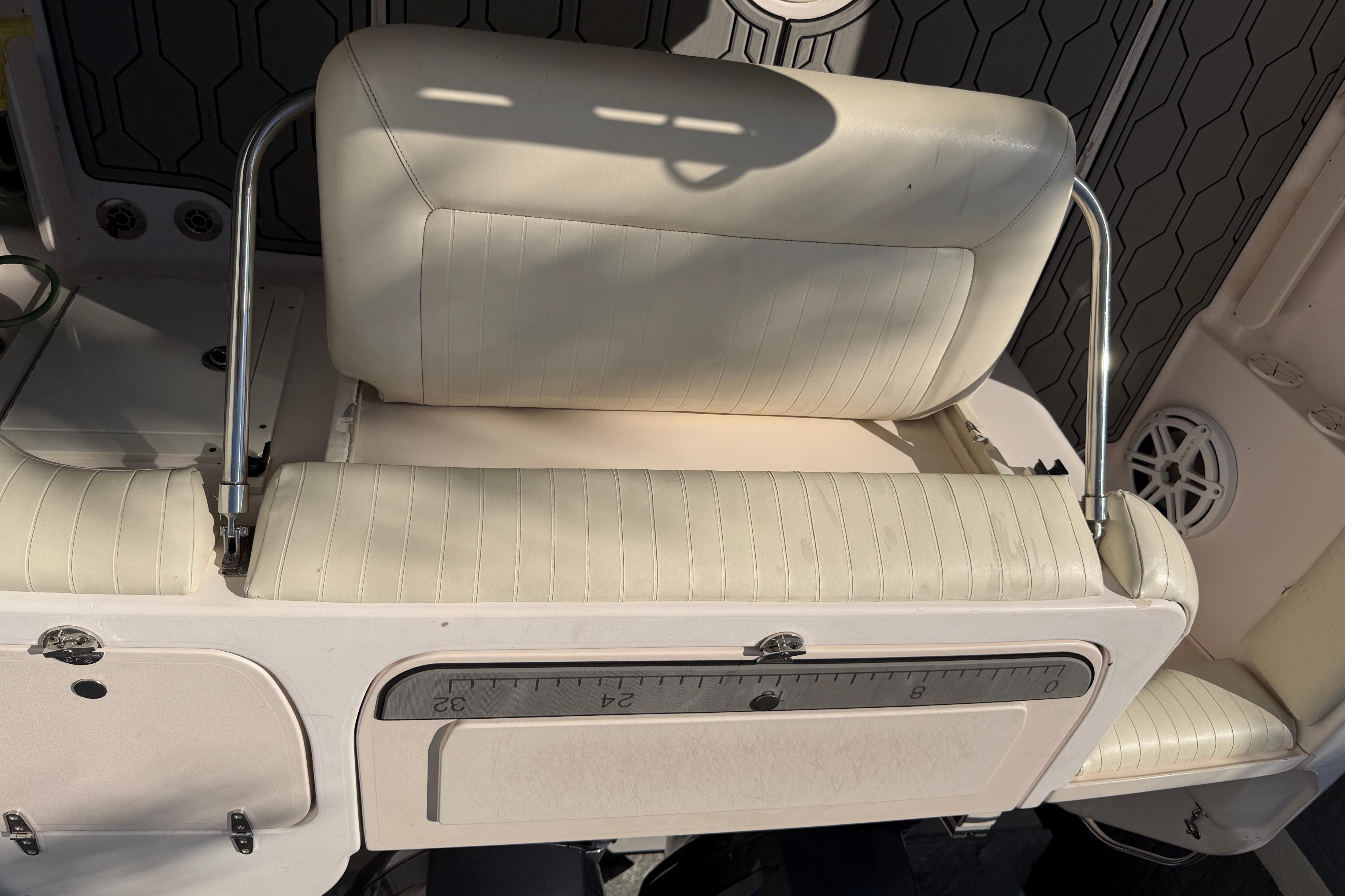 2004 Grady White 273 boat seat with white upholstery and metal supports.