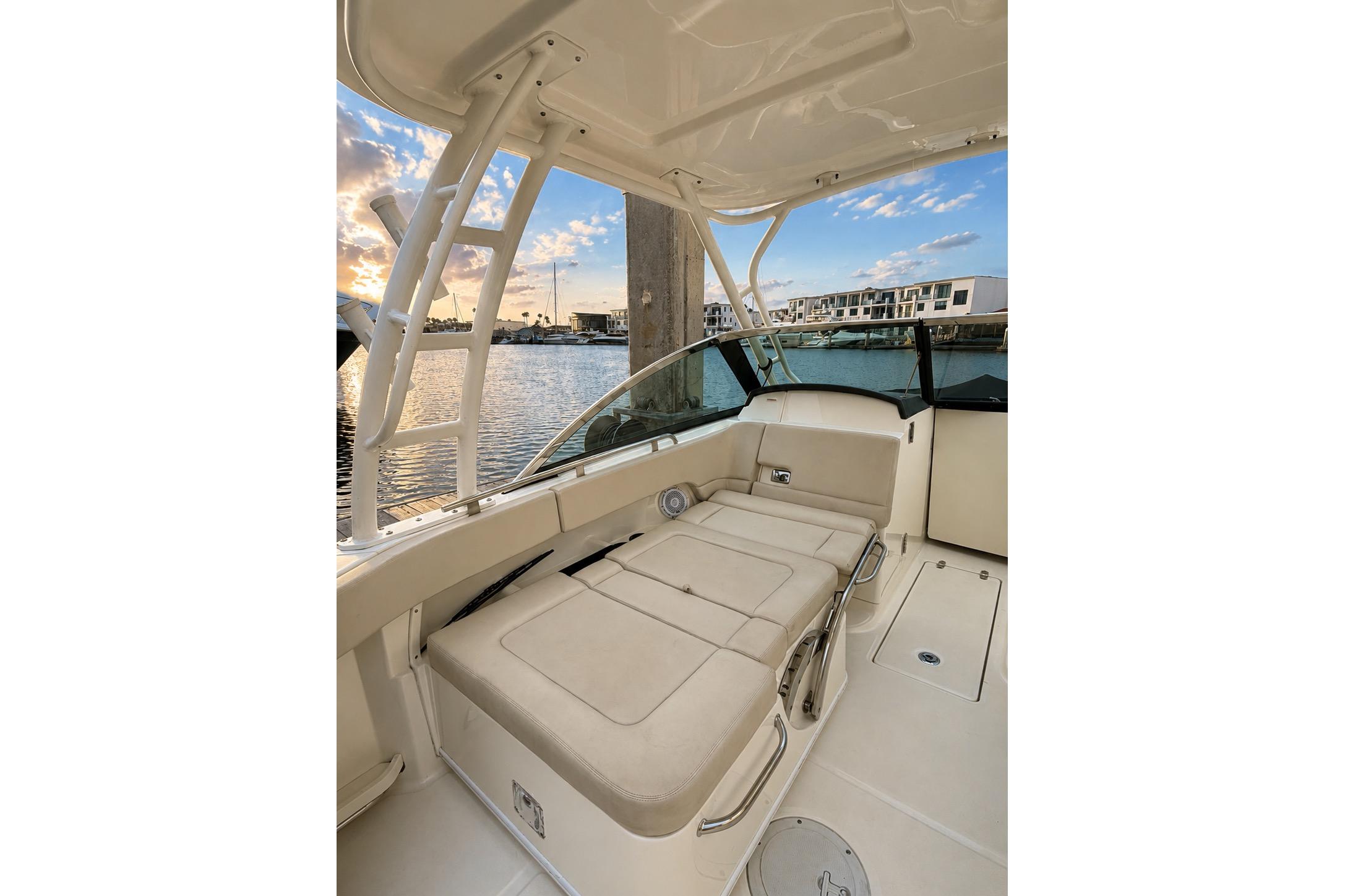 2017 Boston Whaler 230 Vantage interior with beige seating, overlooking marina at sunset.