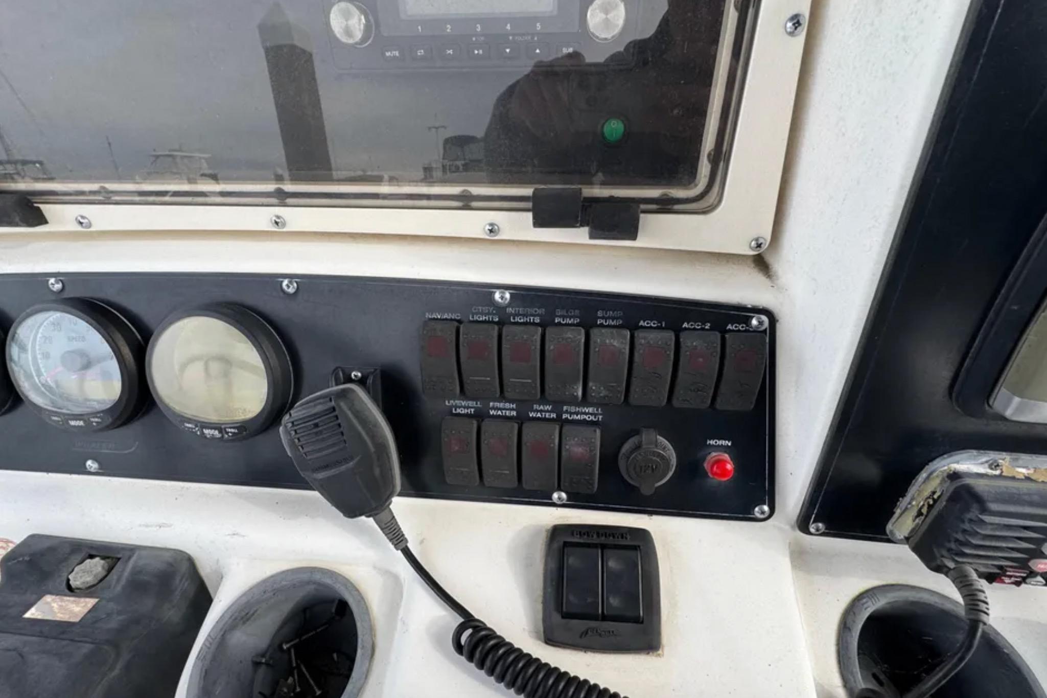 Control panel of a 2001 Boston Whaler 26 Outrage boat with gauges and switches.