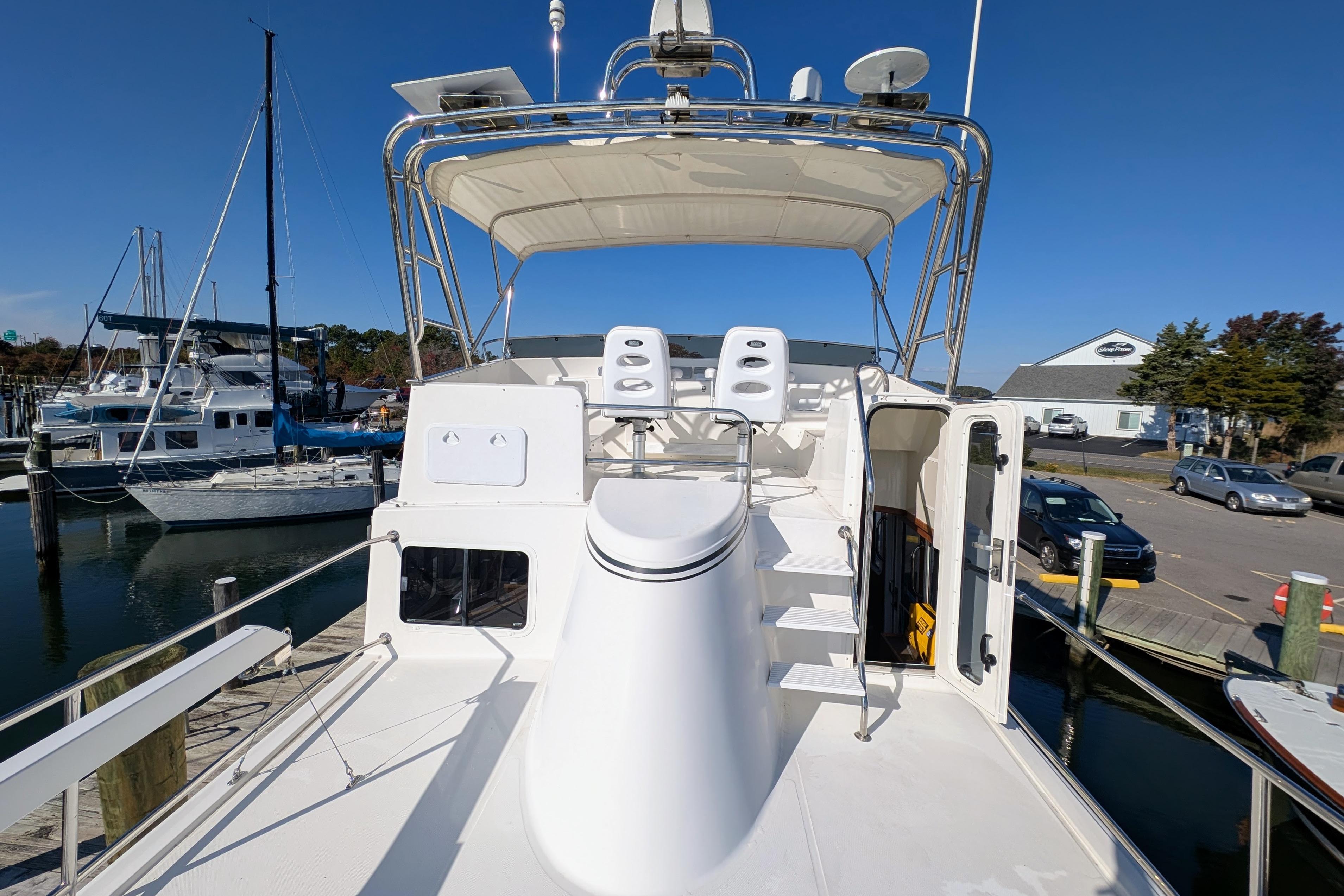 2015 American Tug 435 yacht docked, featuring upper deck seating and marina view.