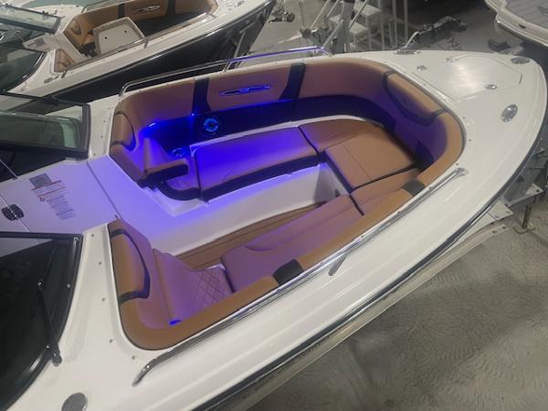 2025 Chaparral 307 SSX boat interior with blue LED lighting and tan seating.