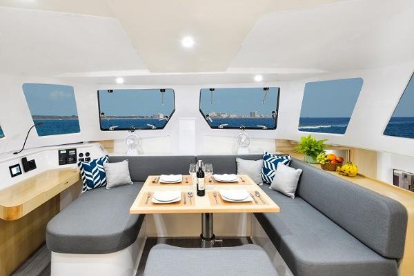 Interior of 2025 Seawind 1170 catamaran with dining area, ocean view, and modern decor.