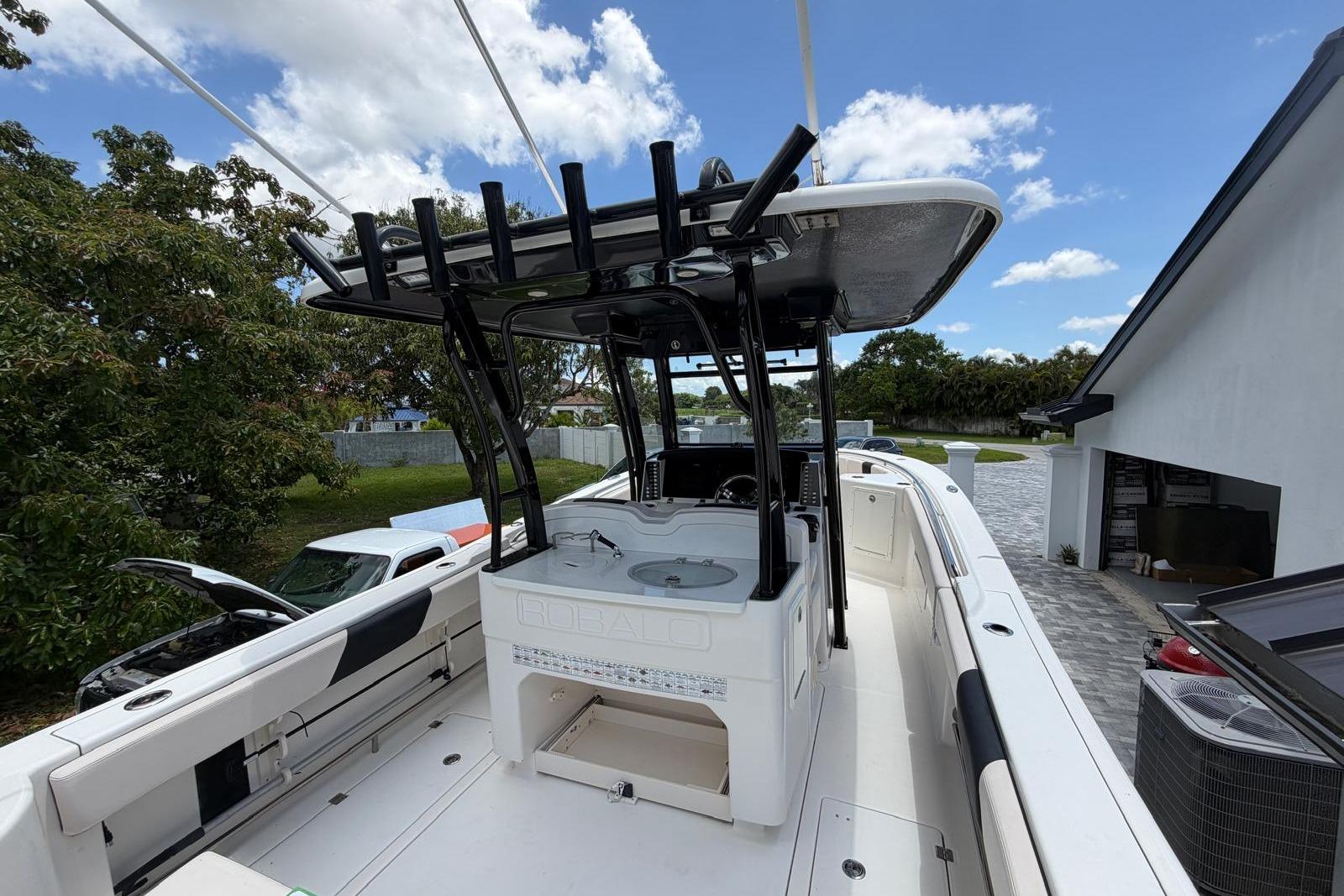 2017 Robalo R302 Center Console boat with T-top, parked outdoors.